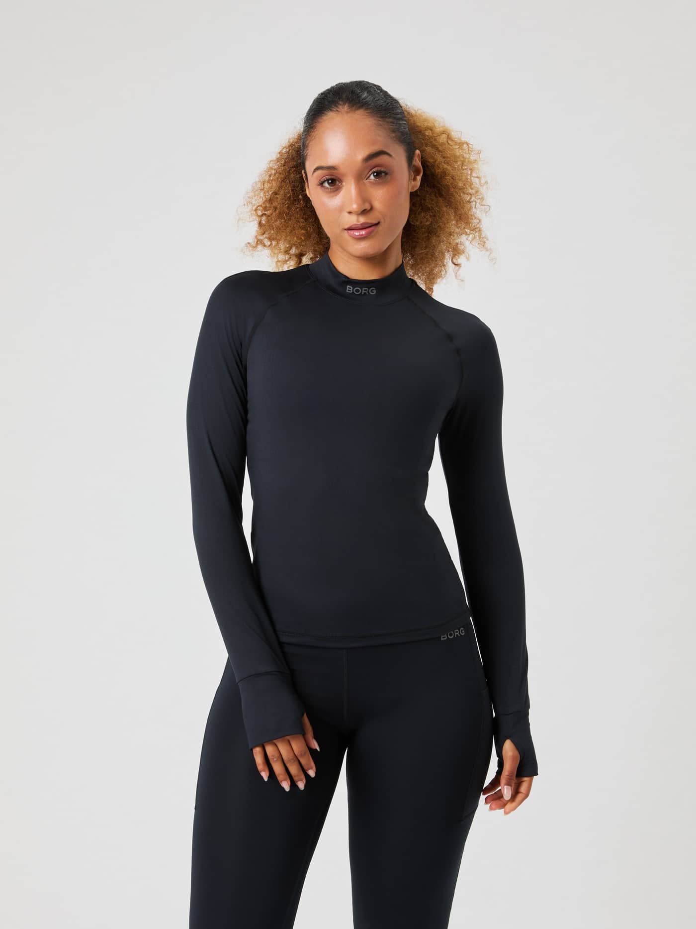 Front view of the Borg Performance Brushed Mockneck in Black Beauty (Black), a sleek running top with a black logo. - Image 1