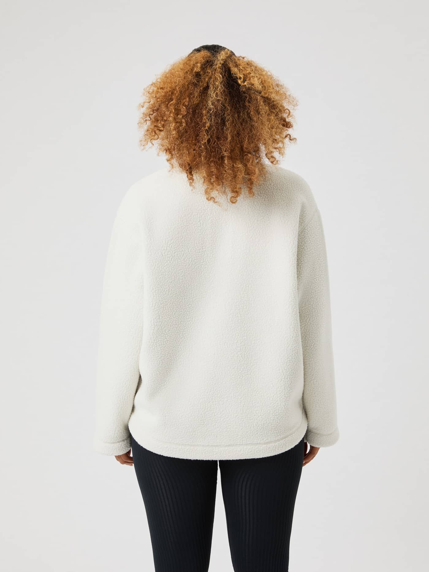 Vista posterior de una mujer con el Studio Pile Anorak en Tofu (Blanco) con un cómodo ajuste extragrande y textura suave. - Image 3