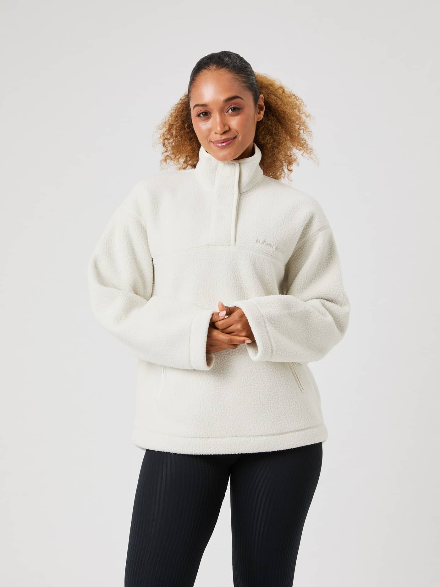 Vista frontal de una mujer con el Studio Pile Anorak en Tofu (Blanco), un anorak de forro polar extragrande con cuello alto. - Image 2