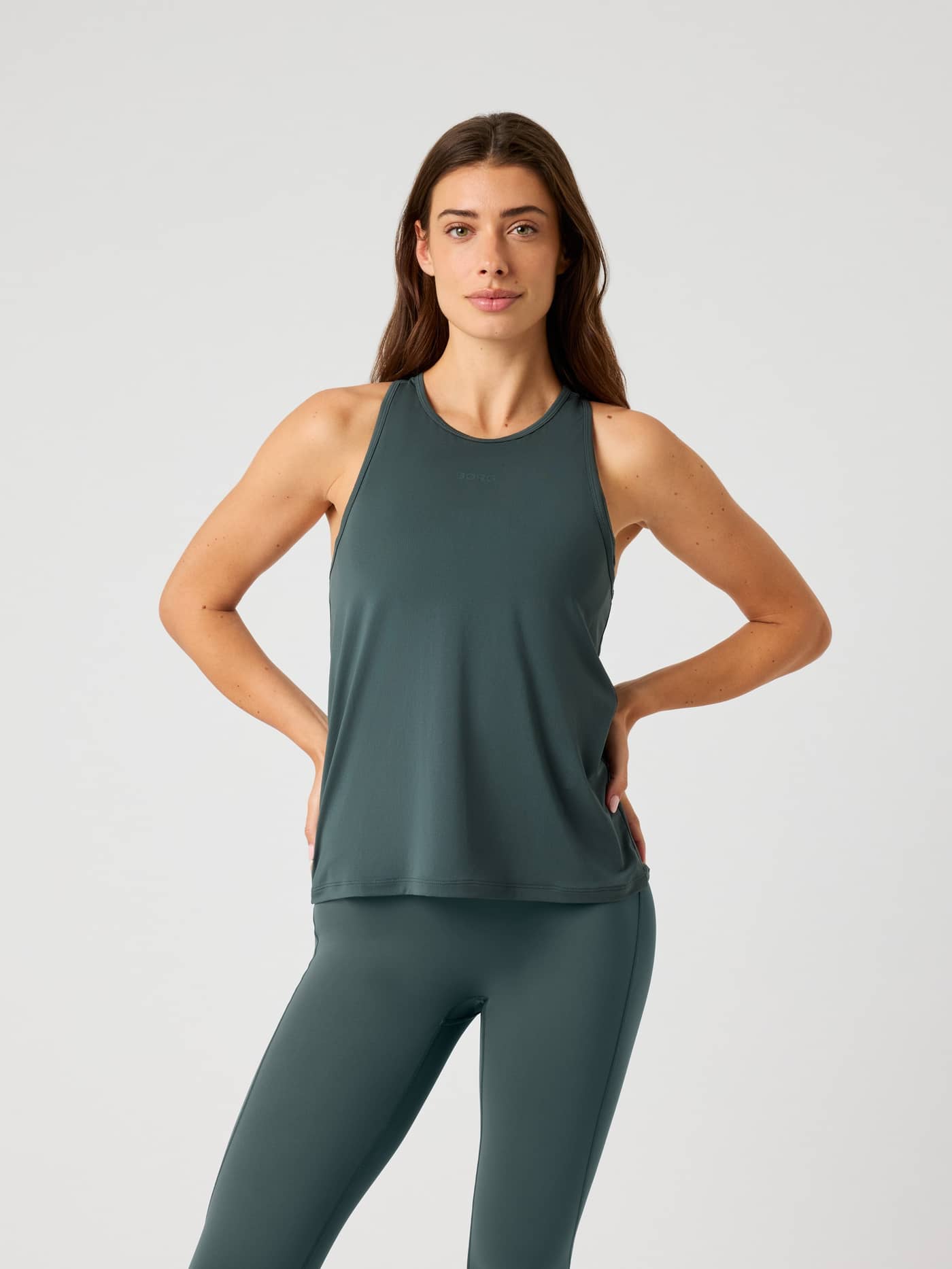 Front view of a model wearing the Borg Sports Tank Top in Urban Chic (Green) with a tonal logo, a stylish training fit. - Image 1