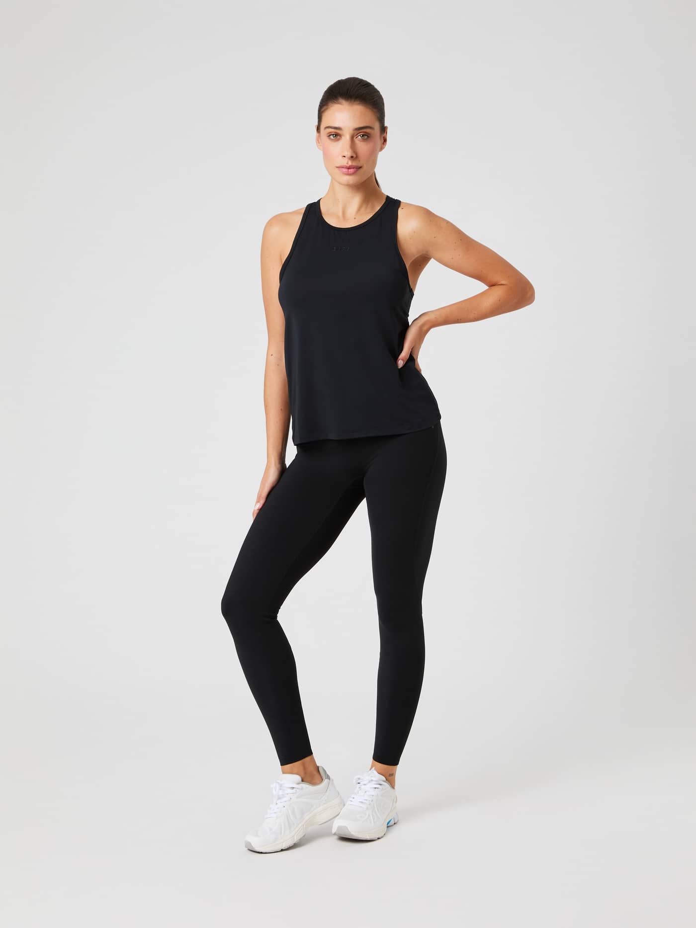Vue en pied du Borg Sports Tank Top en Black Beauty (Noir) avec leggings et baskets blanches pour l'entraînement. - Image 3
