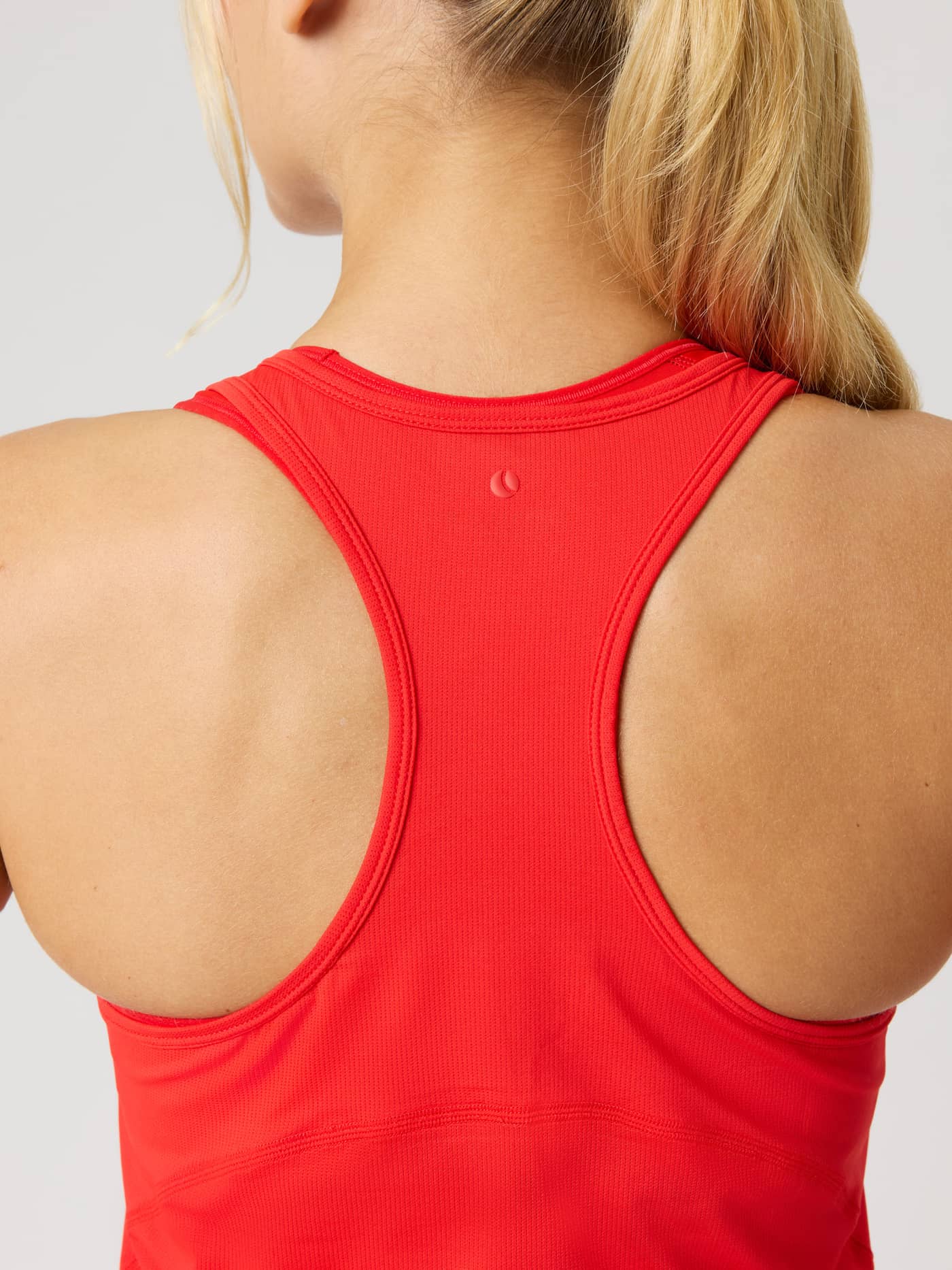 Rückansicht eines Models im Borg Sports Tank Top in Flame Scarlet (Rot) mit tonalem Tennisball-Logo zum Training. - Image 4