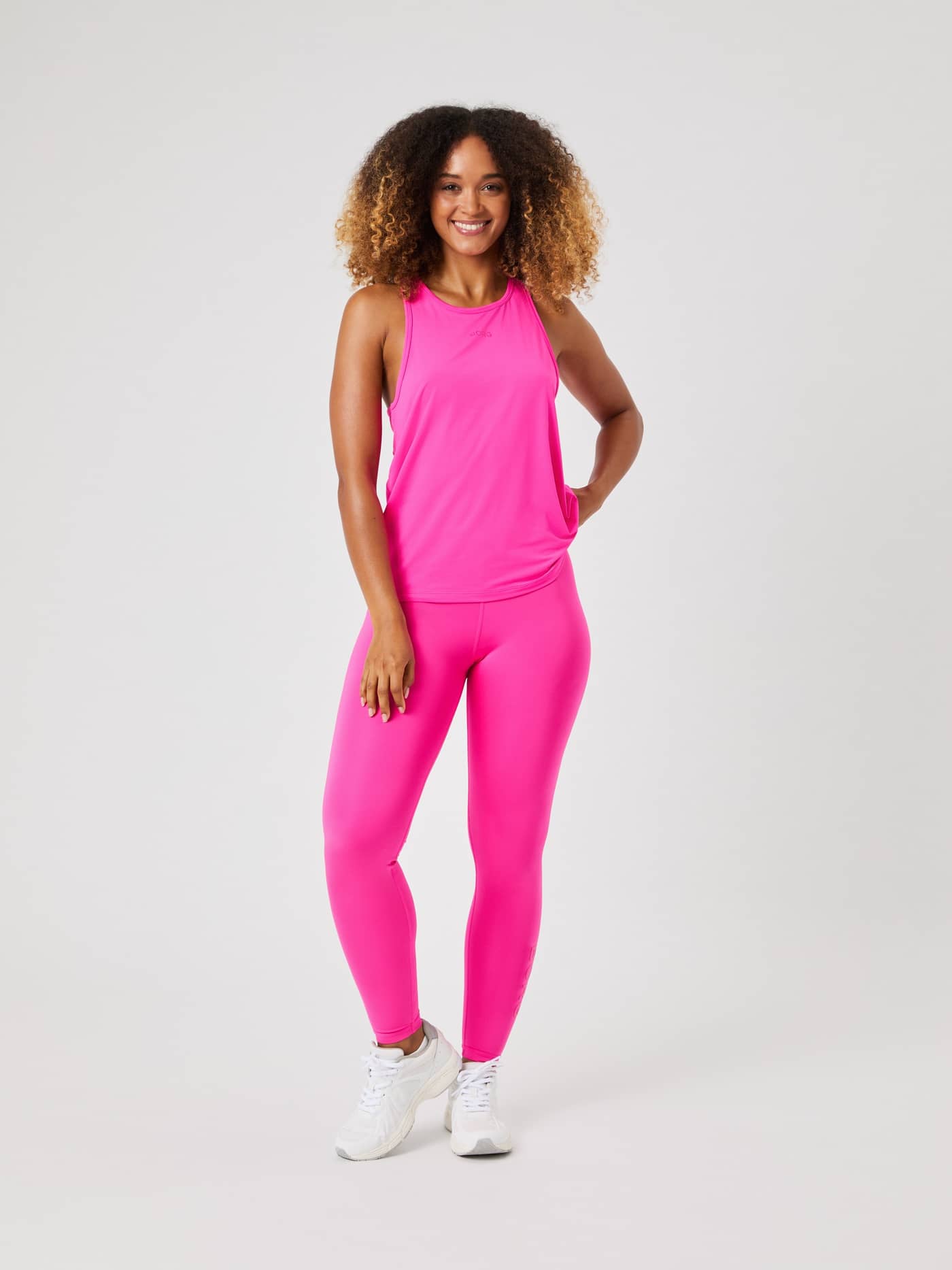 Front view of a model wearing the pink Borg Sports Tank Top paired with matching leggings. - Image 3