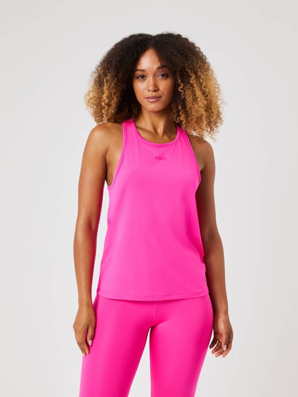 Front view of a model wearing the bright pink Borg Sports Tank Top with matching leggings.