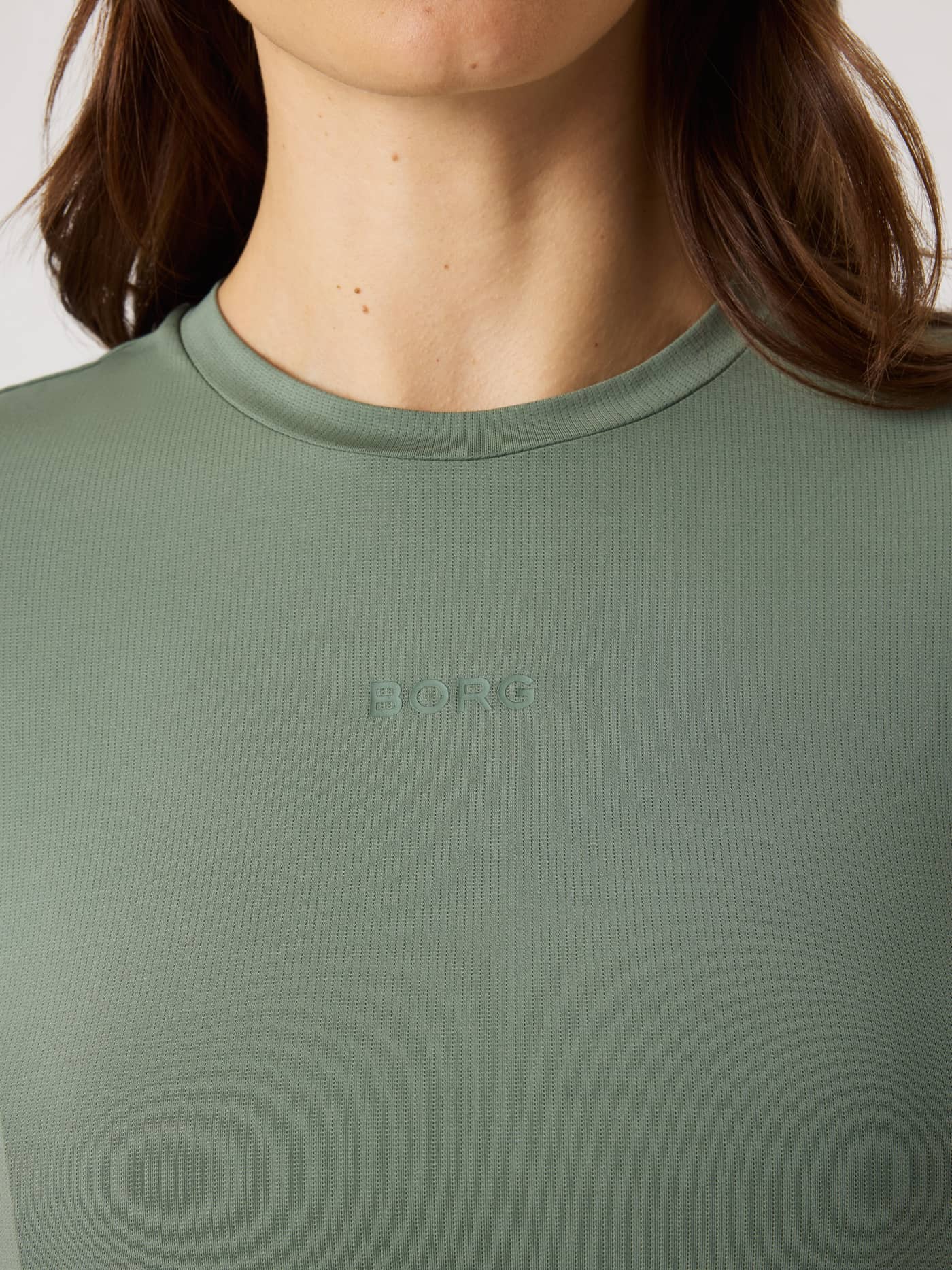 Nahaufnahme des Borg Sports T-Shirt in Agave Green (Grün) aus atmungsaktivem Trainingsmaterial mit zentralem grünem Logo. - Image 4