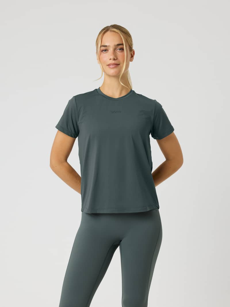 Front view of a woman wearing the Borg Sports T-Shirt in Urban Chic (Green) for training with a tonal chest logo.