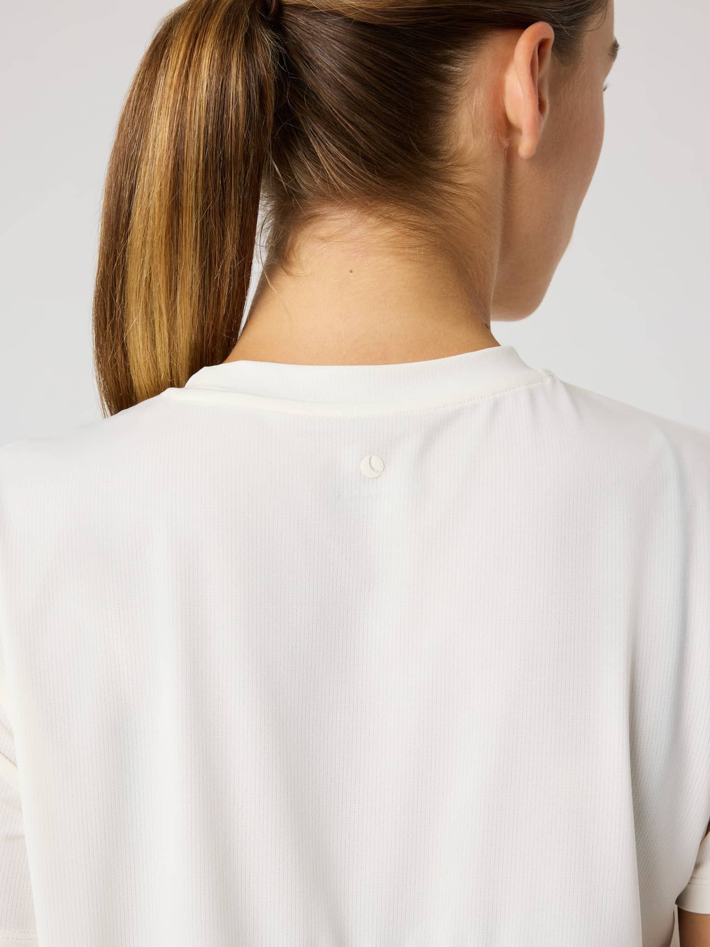 Back view of a model wearing the Borg Sports T-Shirt in Tofu (White), a training style with a white tennis ball logo. - Image 4