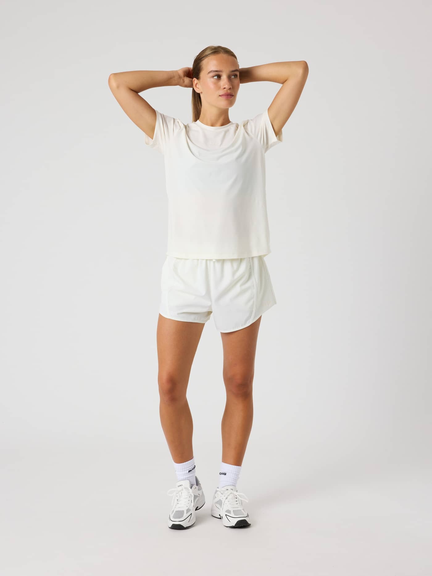 Full-body front view of a woman wearing the Borg Sports T-Shirt in Tofu (White), featuring a stylish fit for training. - Image 3
