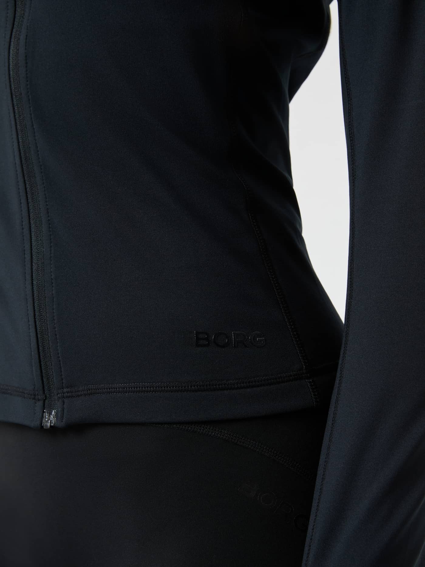 Close-up of the black Borg Full Zip Midlayer showing the tonal logo on the chest. - Image 5