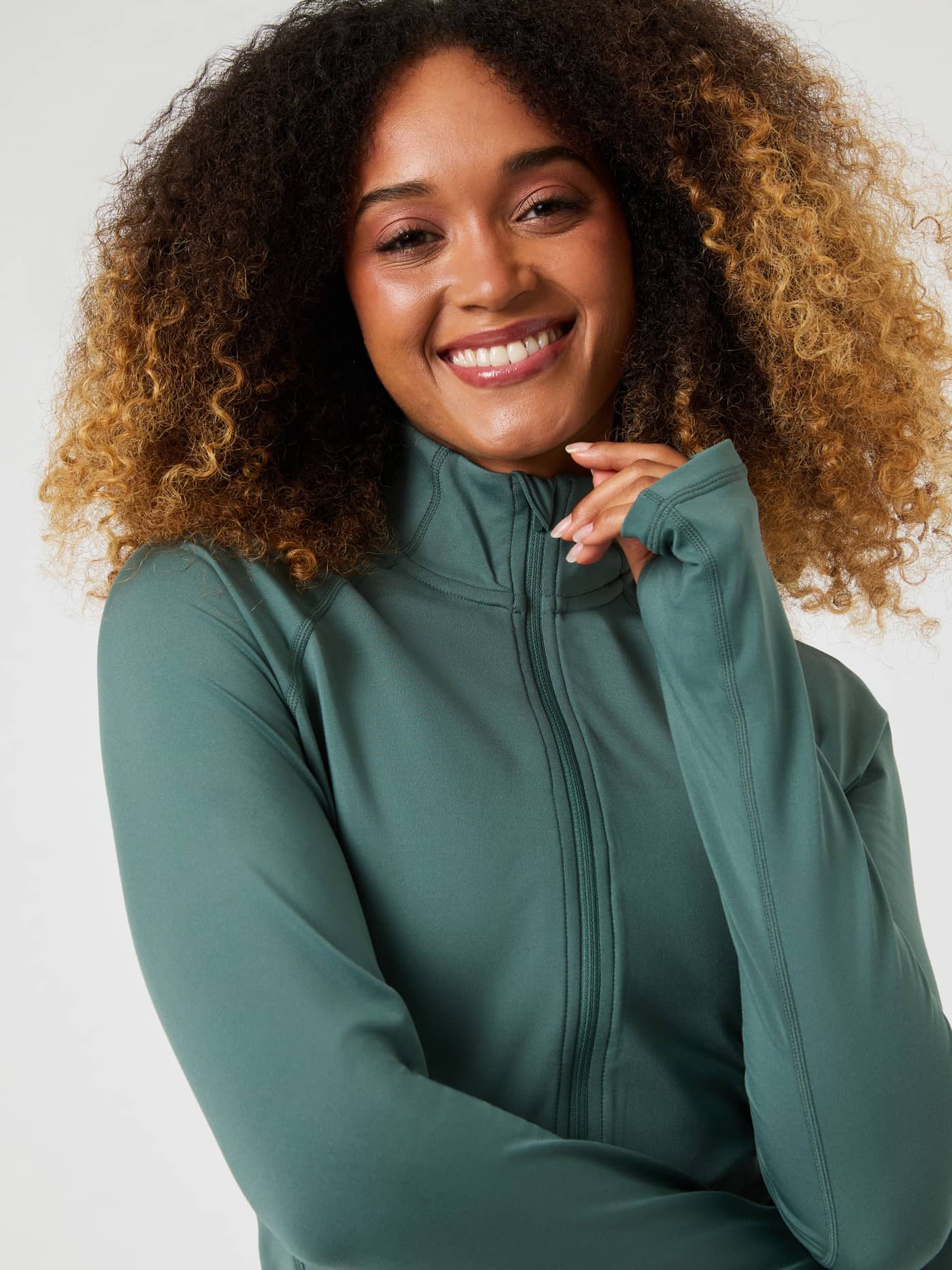 Nahaufnahme einer lächelnden Frau im Borg Full Zip Midlayer in Balsam Green (Grün) für Training mit stilvollem Fit. - Image 1