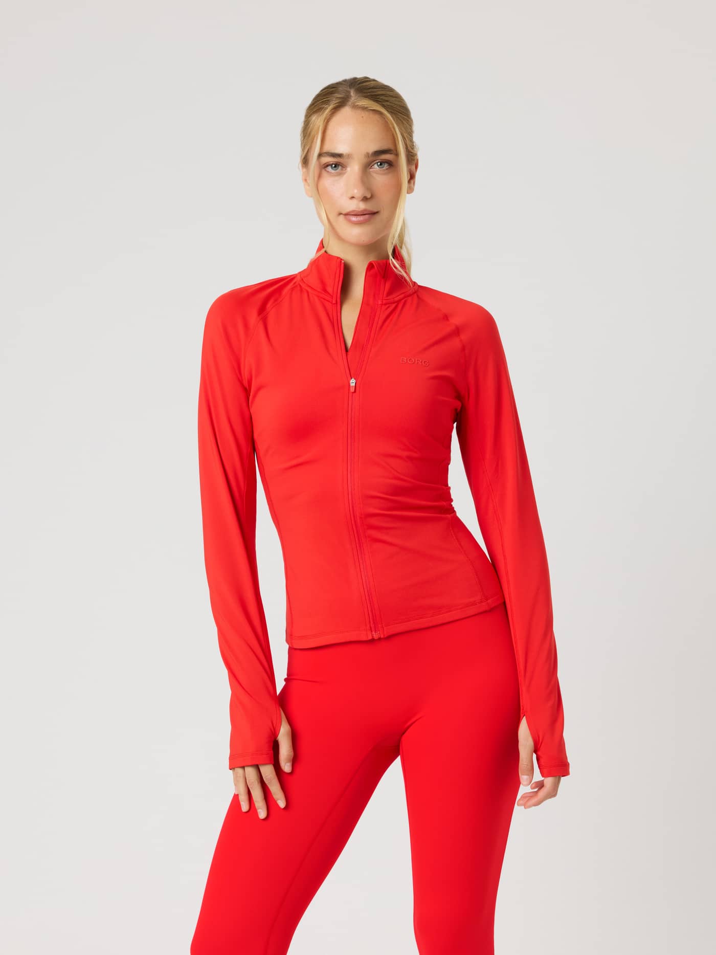 Borg Full Zip Midlayer i Flame Scarlet (Rød) set forfra på en kvinde til performance-træning. - Image 1