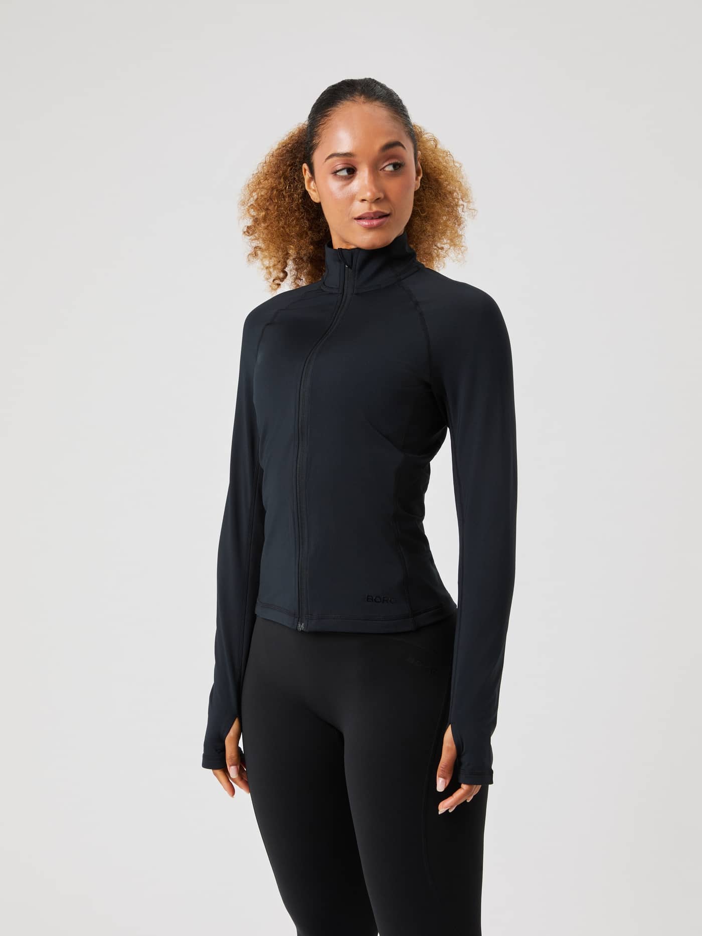 Front view of a model wearing the black Borg Full Zip Midlayer against a grey background. - Image 3