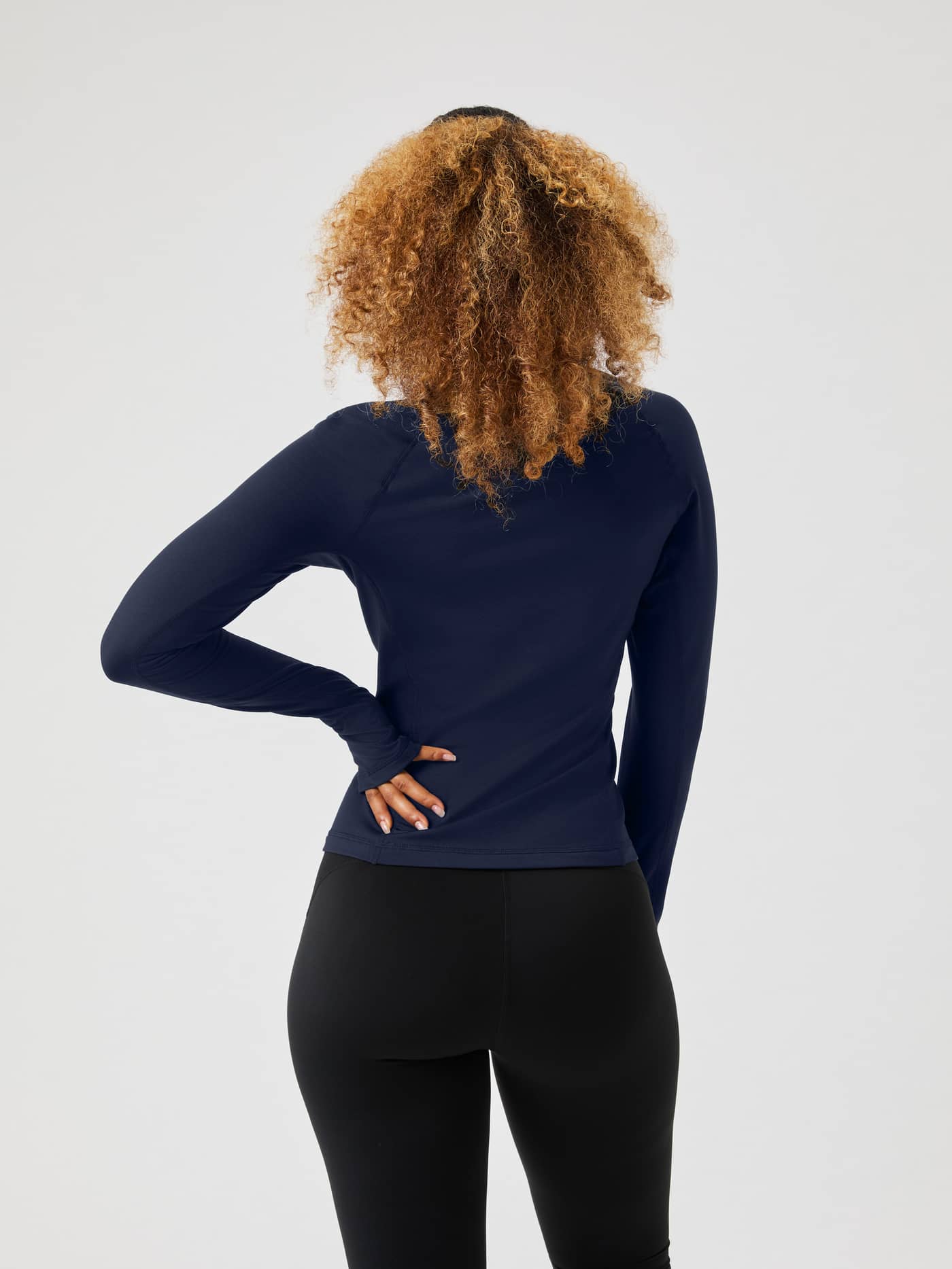 Back view of a woman in the slim-fit Borg Full Zip Midlayer in Night sky (Navy), perfect for training and tennis. - Image 2