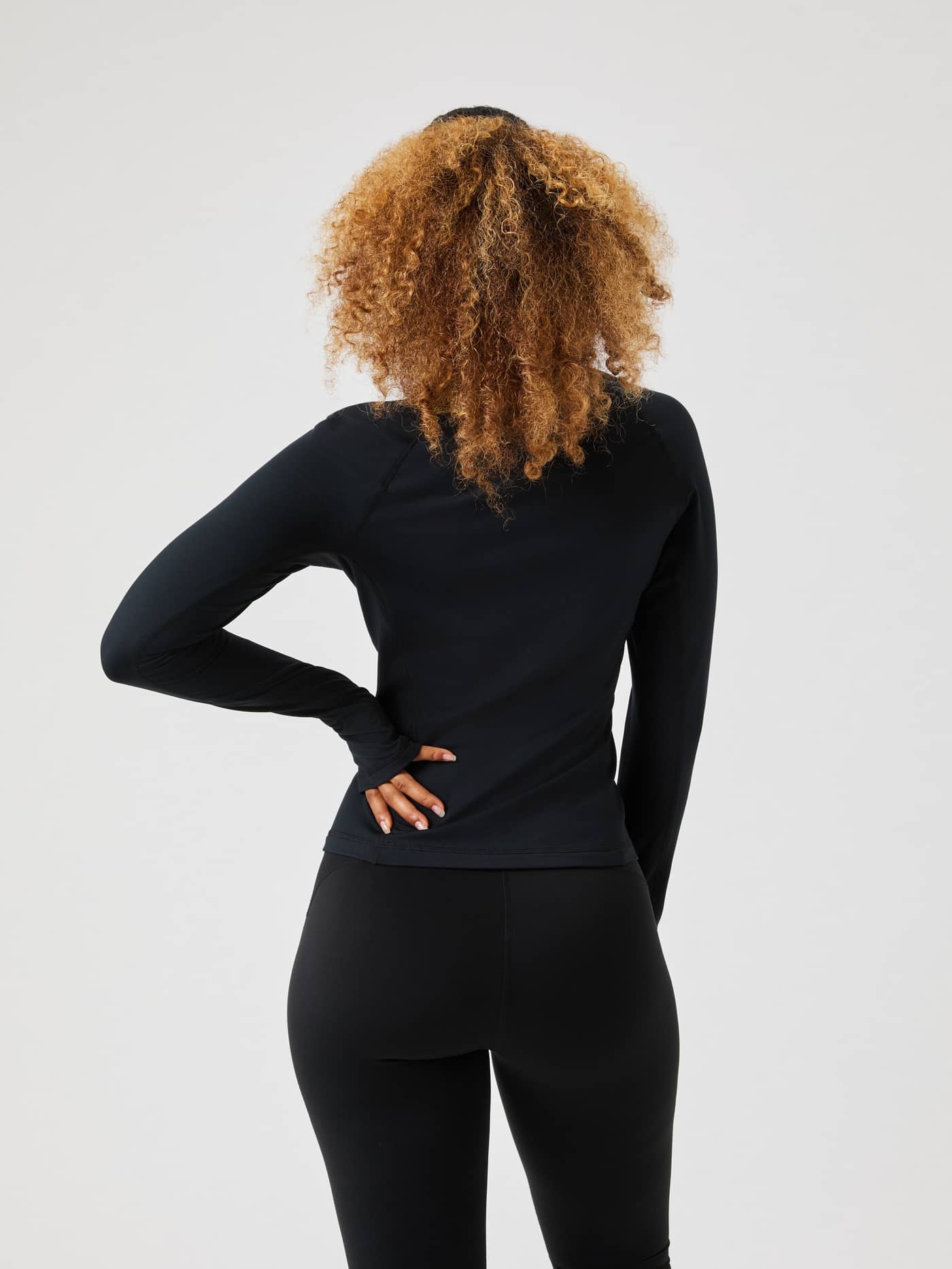 Back view of the black Borg Full Zip Midlayer on a model, showcasing its slim fit and thumbhole feature. - Image 4