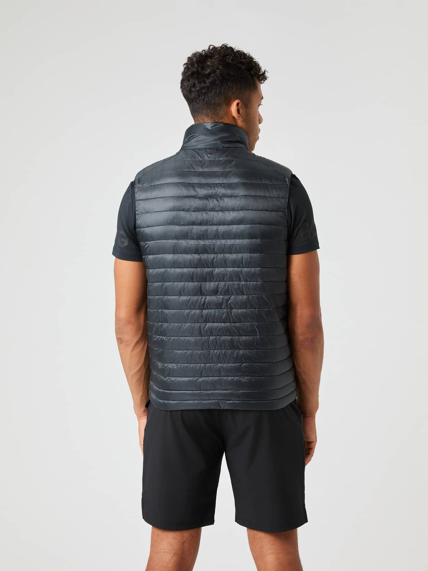 Back view of a man wearing the Björn Borg Light Padded Vest in Black Beauty (Black), a quilted layer with a tonal logo. - Image 2