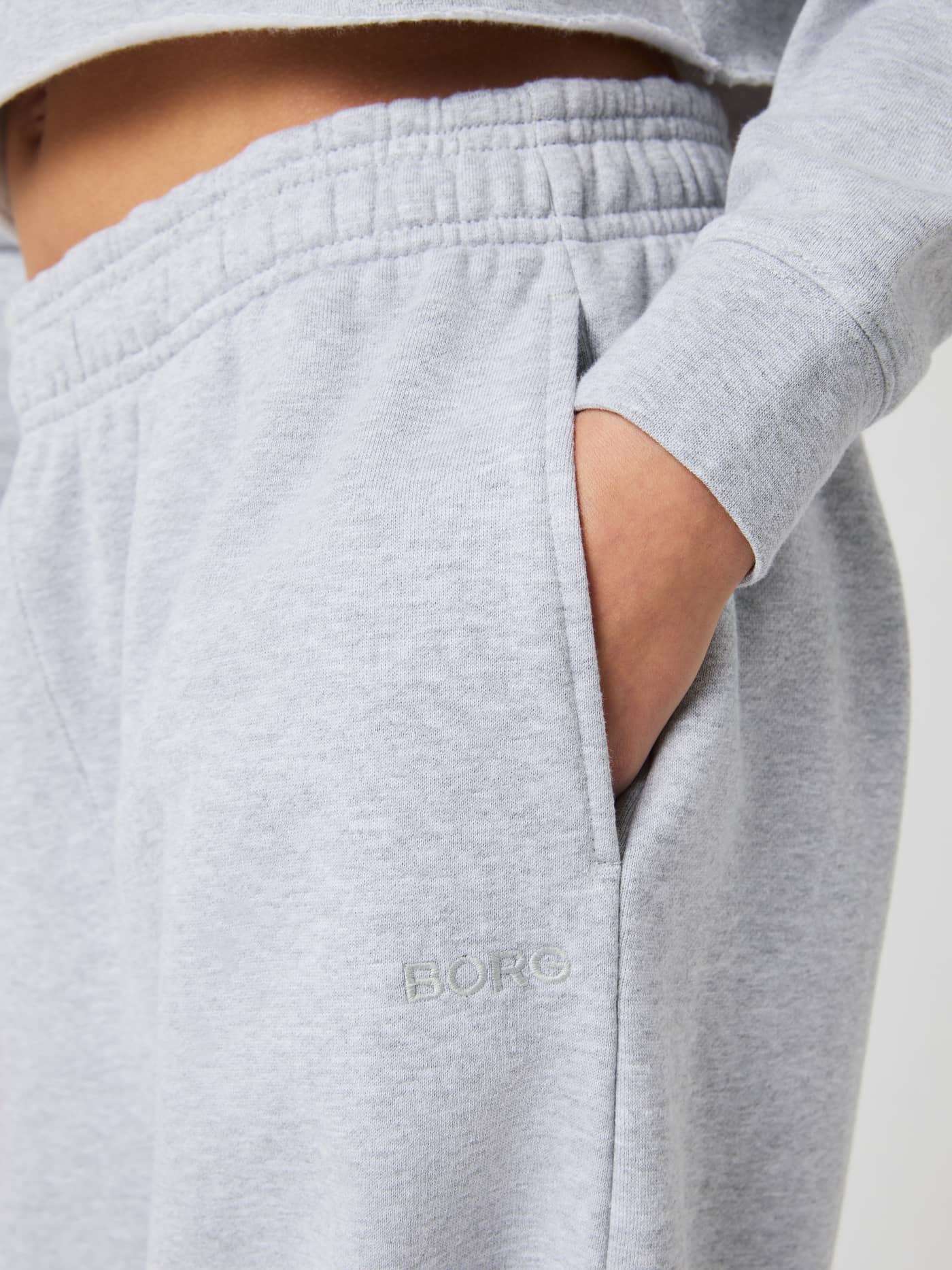 Close-up of kids' Borg Oversized Sweatpants in Light Grey Melange (Grey), featuring a side pocket and tonal logo. - Image 4