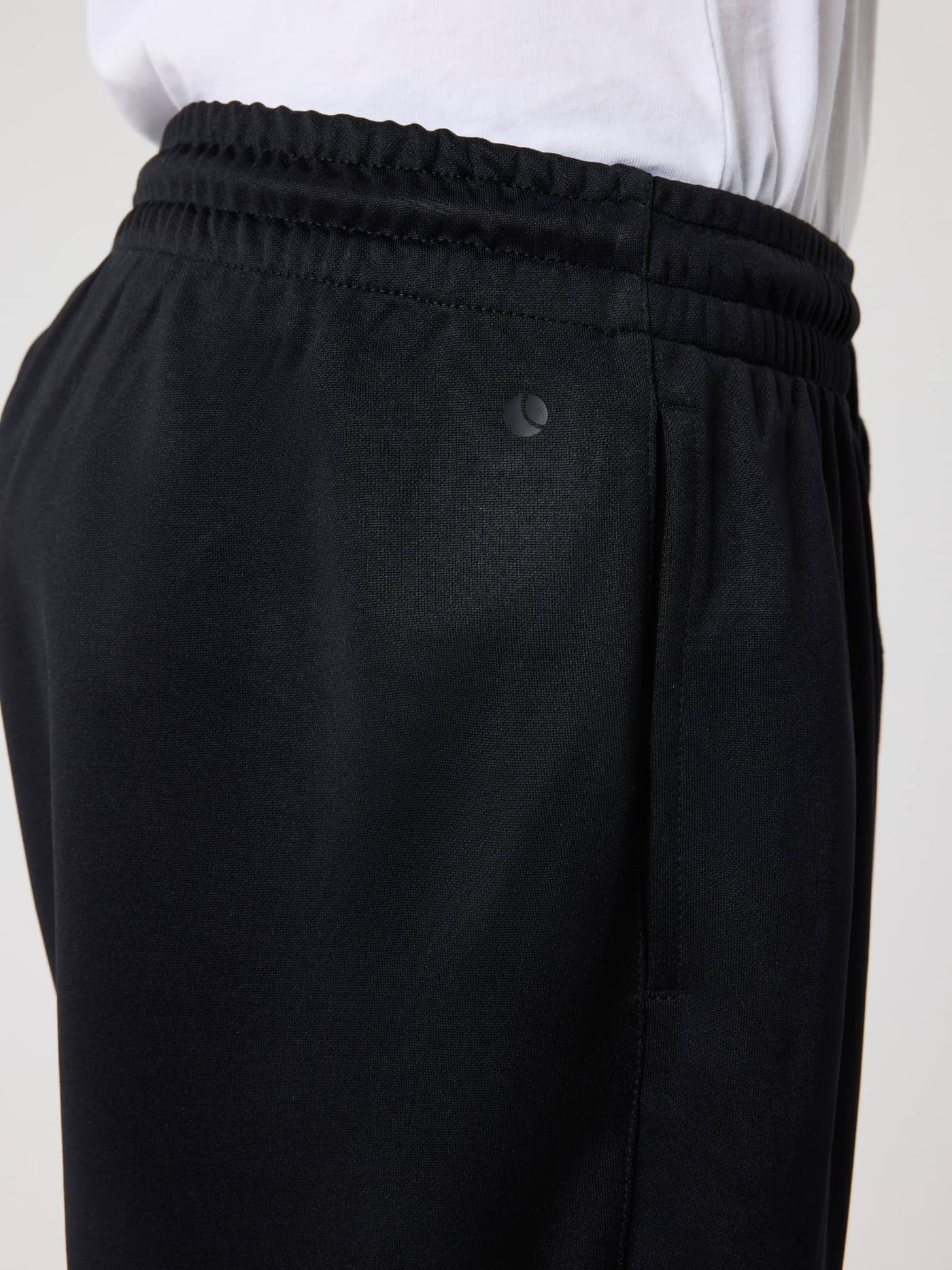 Close-up of the waistband and tonal logo on kids' Borg Active Pants in Black Beauty (Black) for training. - Image 3