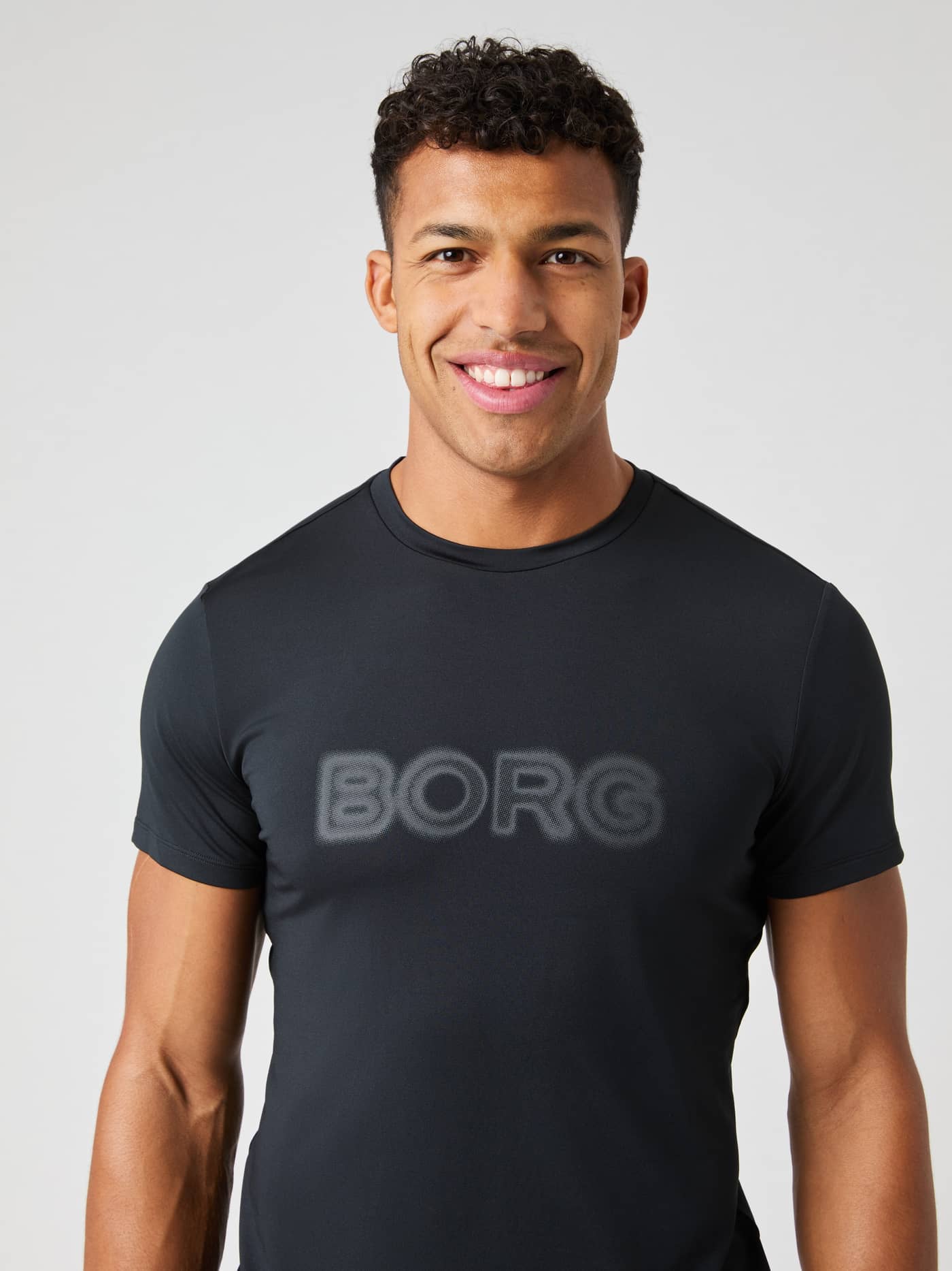 Borg Graphic T-Shirt i Black Beauty (Sort) set forfra med et gråt logo, ideel til funktionel træning. - Image 1