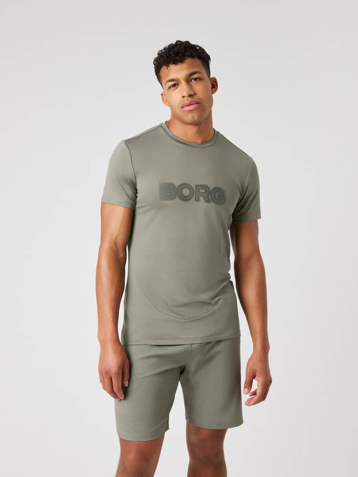 Vooraanzicht van een model in het Dusty Olive (Groen) Borg Graphic T-Shirt, een functionele top voor topprestaties. - Image 2