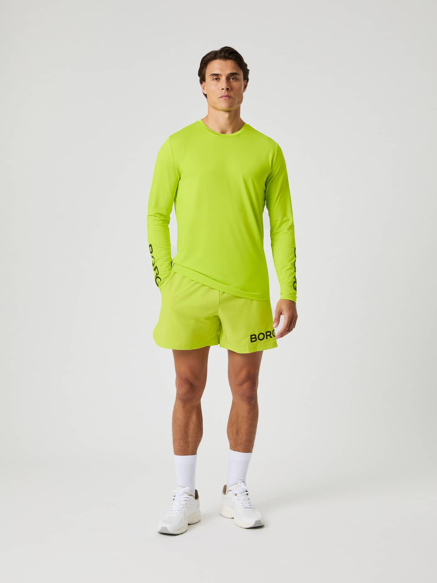Borg Long Sleeve T-Shirt i Acid Lime (Grön) på en man sedd framifrån med matchande shorts för träning. - Image 3