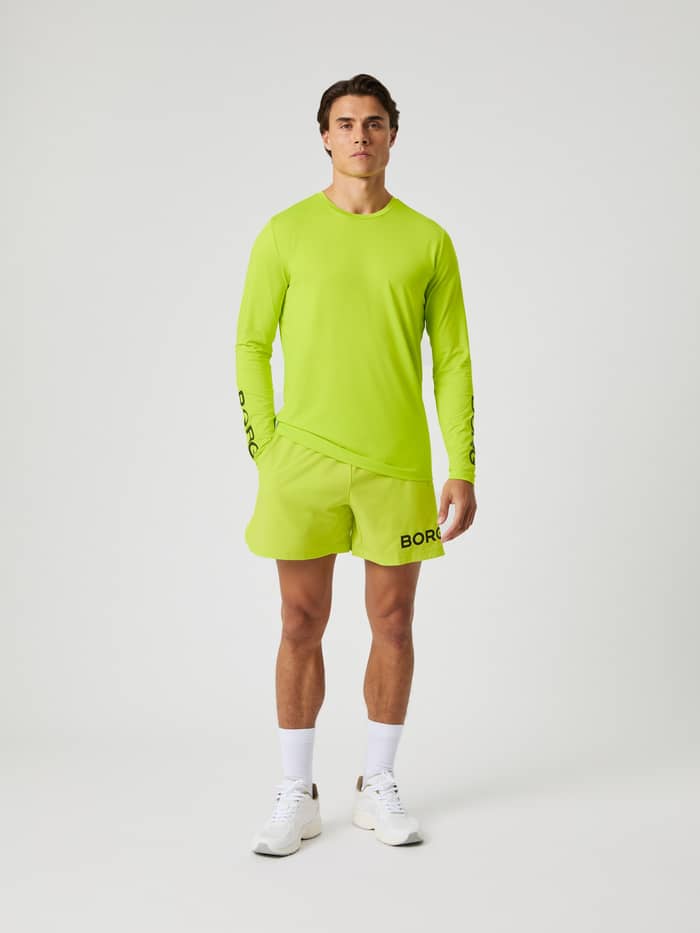 Vooraanzicht van een man in het Acid Lime (Groen) Borg Long Sleeve T-Shirt met zwart logo voor training. - Image 3