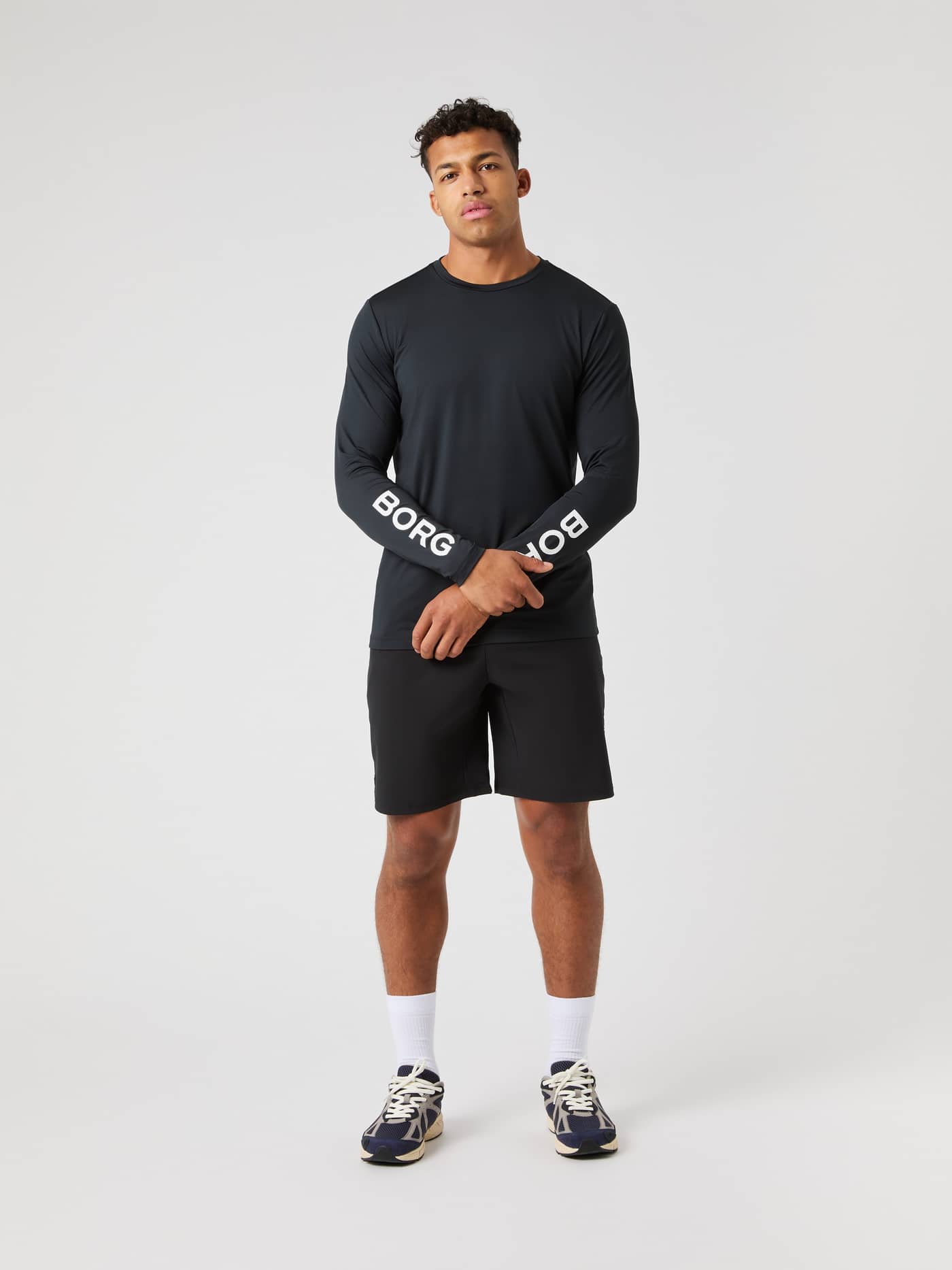 Front view of a model wearing the black Borg Long Sleeve T-Shirt and matching black training shorts. - Image 3