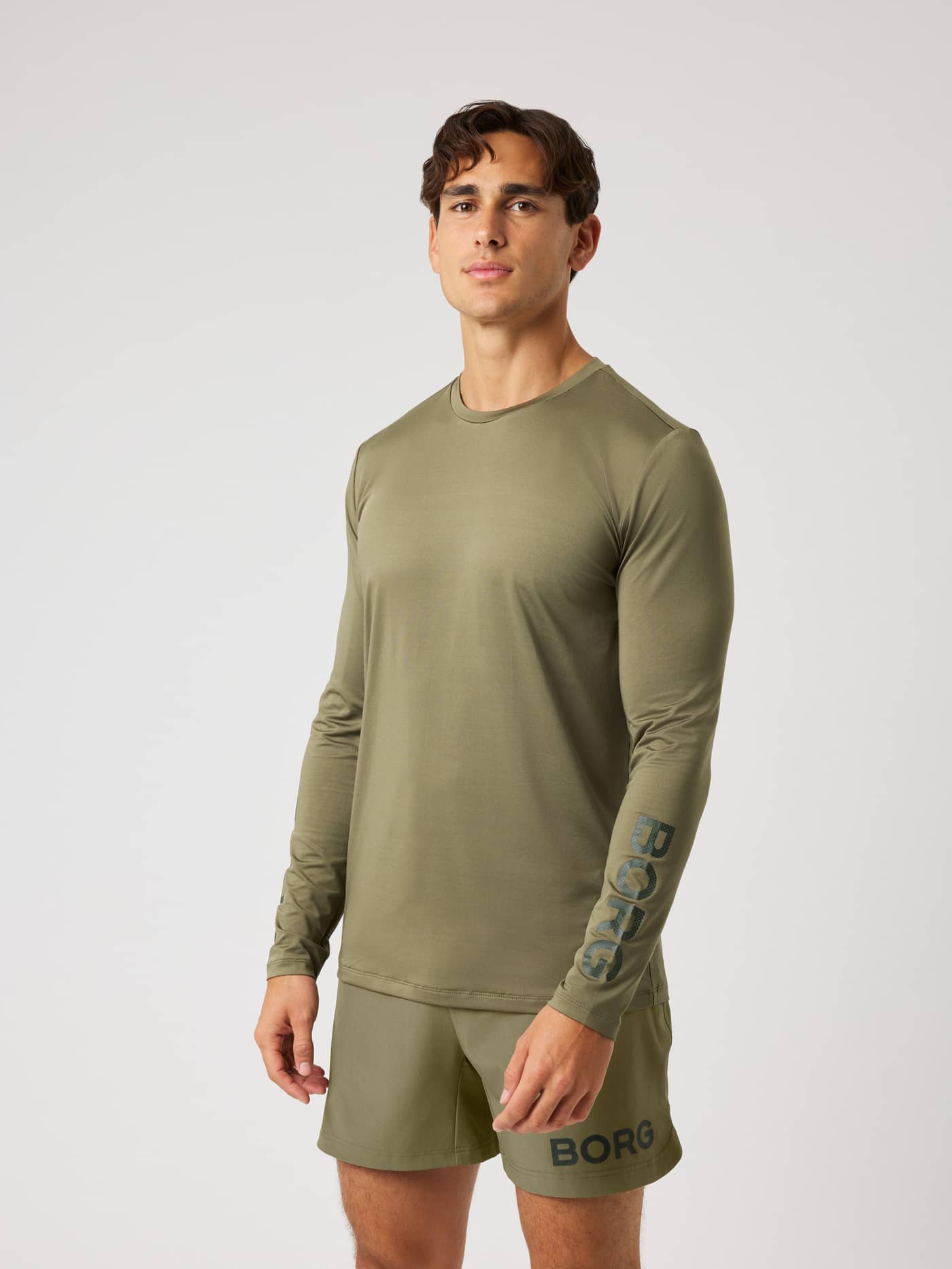 Borg Long Sleeve T-Shirt in Kalamata (Green) with a dark sleeve logo, worn by a model for training and tennis. - Image 2
