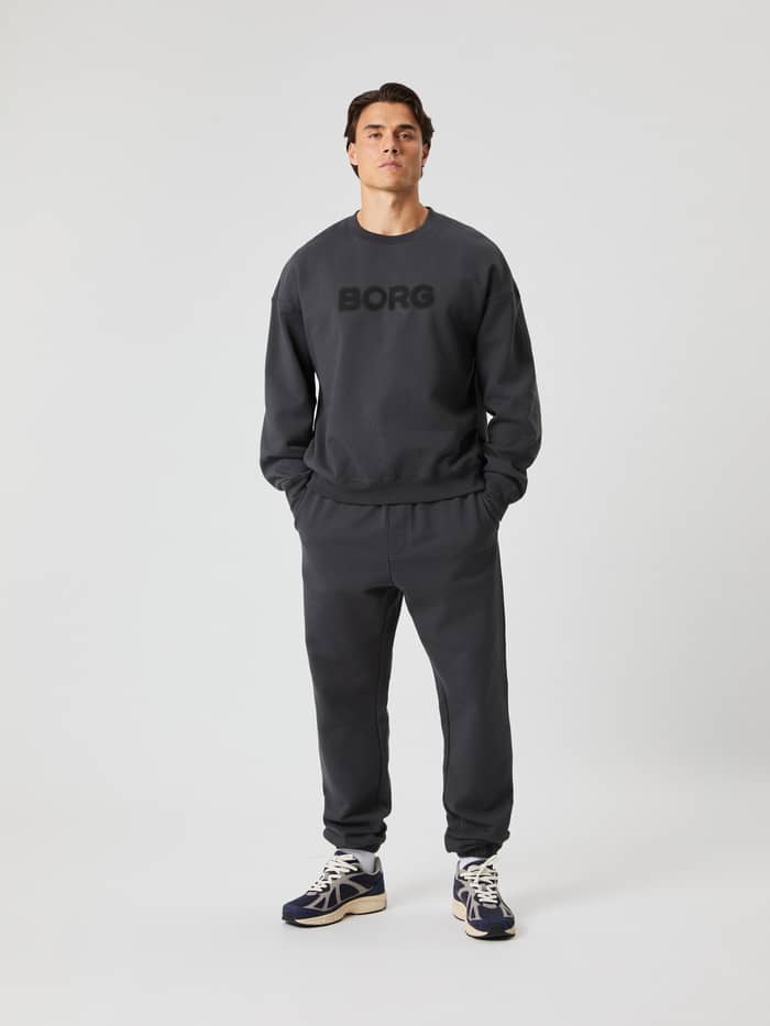Vooraanzicht van een man in het Borg Oversized Sweatshirt in Asphalt (Grijs) met een zwart logo voor stijl en functie. - Image 4