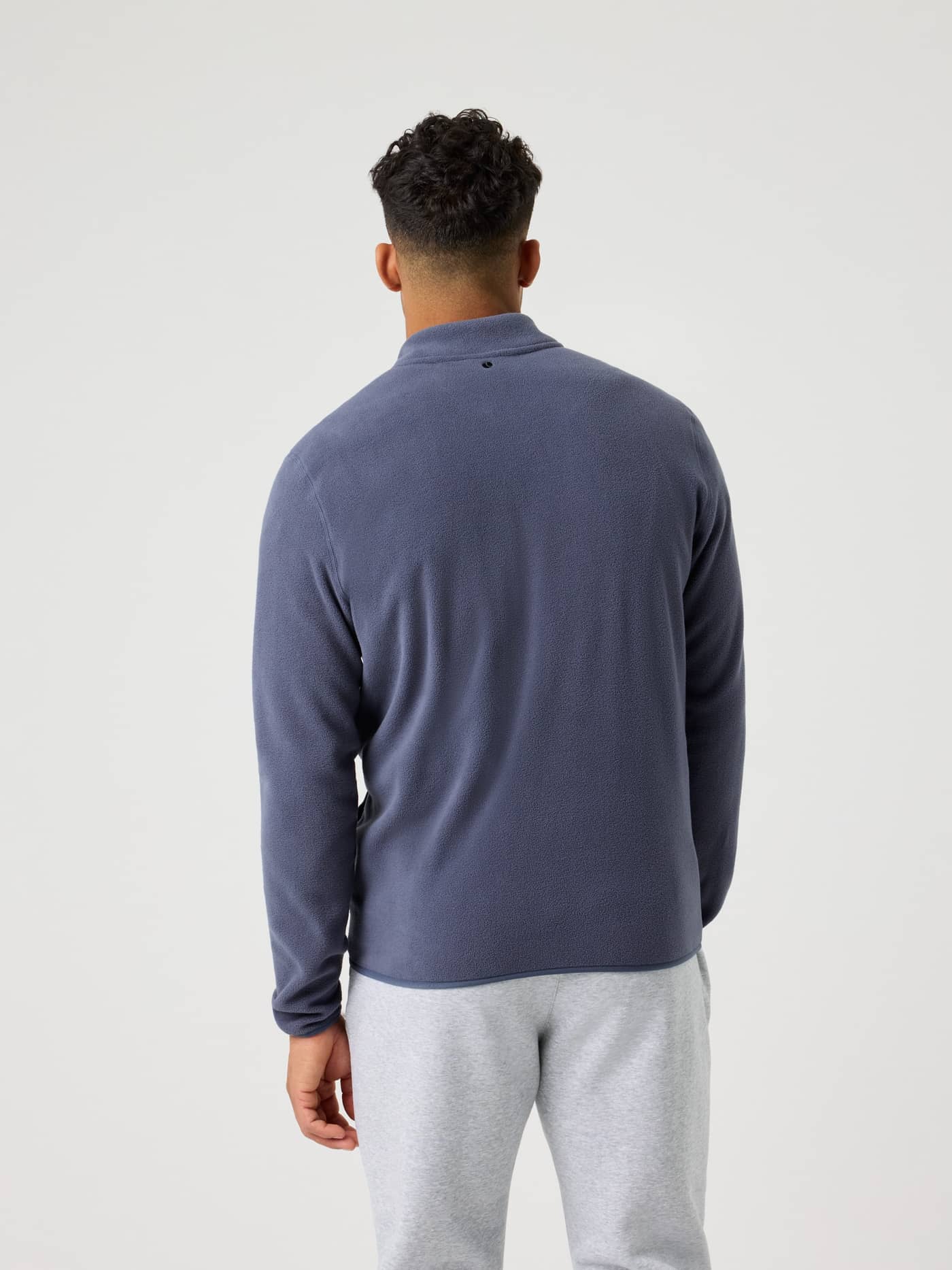 Back view of a man wearing the Odyssey Gray (Blue) Borg Half Zip Fleece, for functional style and performance. - Image 4