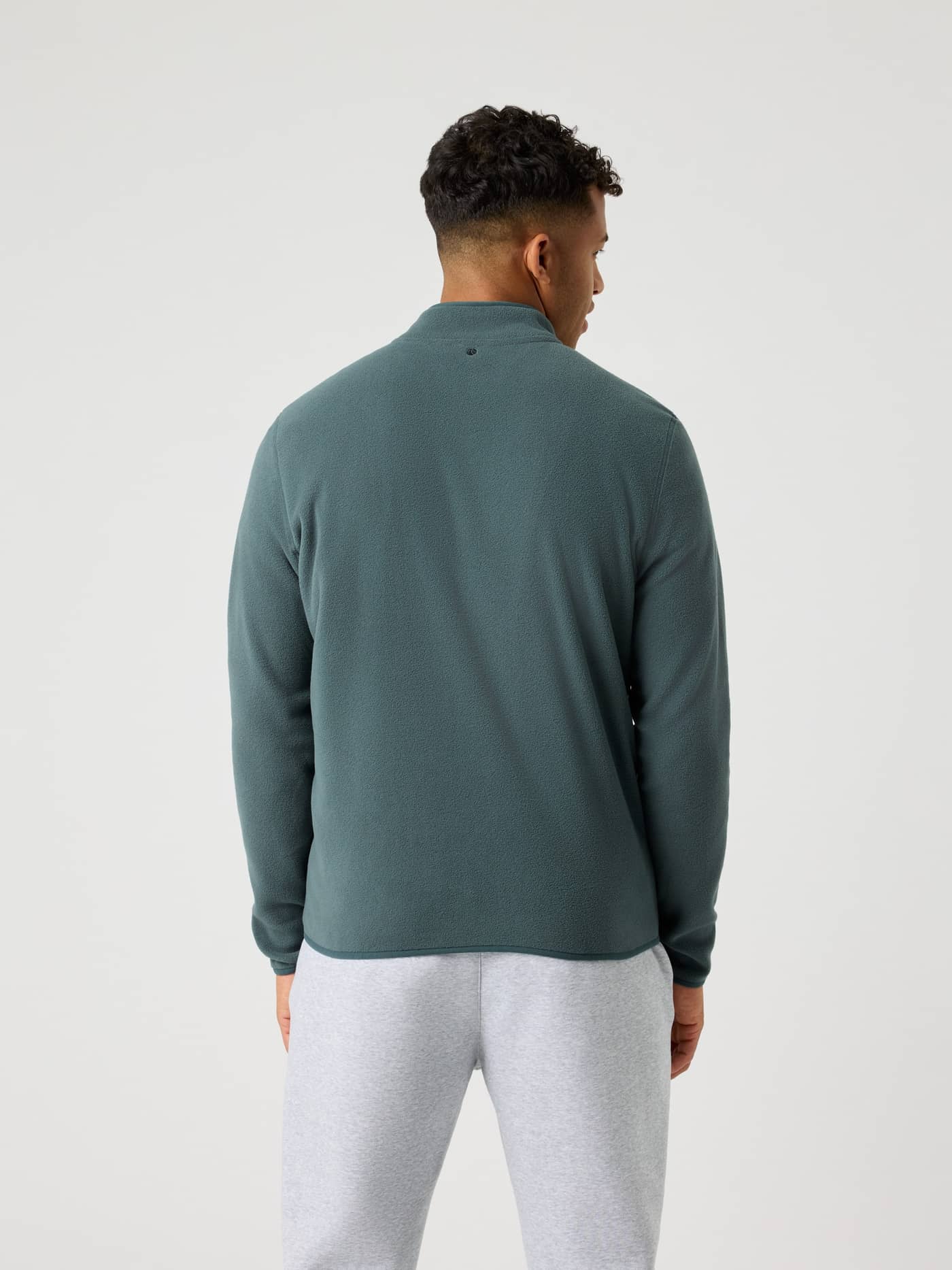 Back view of a man wearing the Borg Half Zip Fleece in Urban Chic (Green), providing a functional and stylish fit. - Image 2