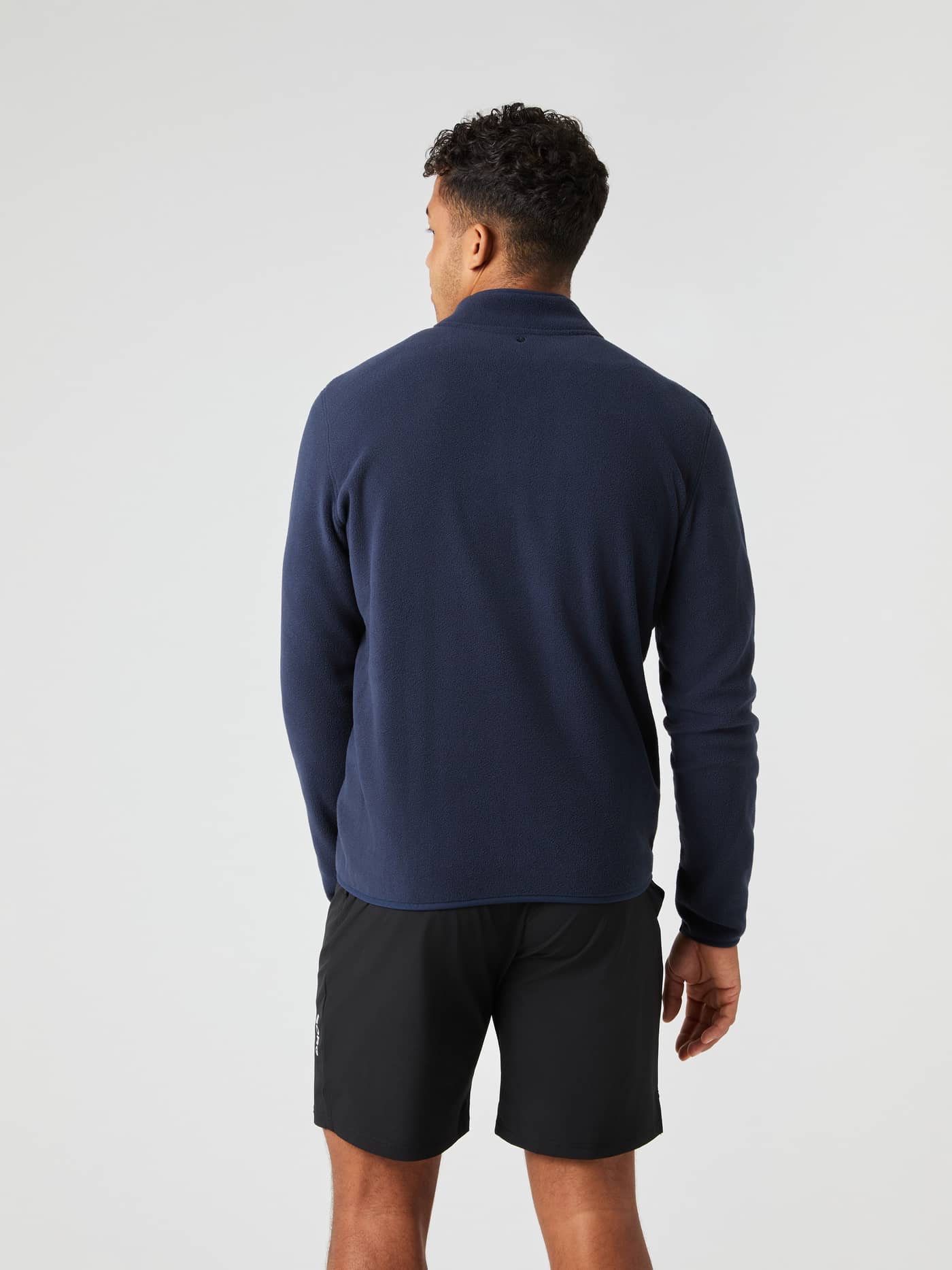 Vista posterior de un modelo con el Borg Half Zip Fleece en Night Sky (Azul marino) con estilo funcional de capa intermedia. - Image 2