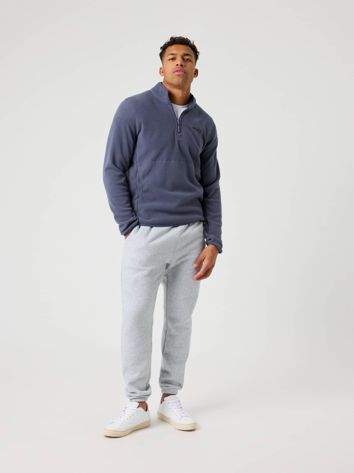Full-body front view of a model wearing the stylish and functional Borg Half Zip Fleece in Odyssey Gray (Blue). - Image 1