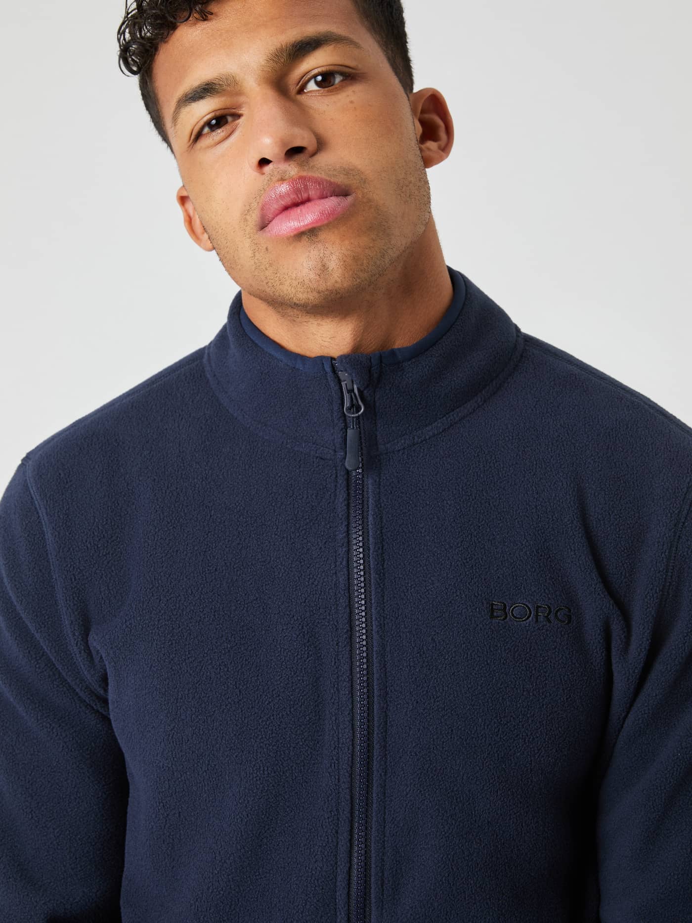 Front view of a man wearing the Borg Full Zip Fleece in Night sky (Navy) with a black BORG logo on the chest. - Image 4