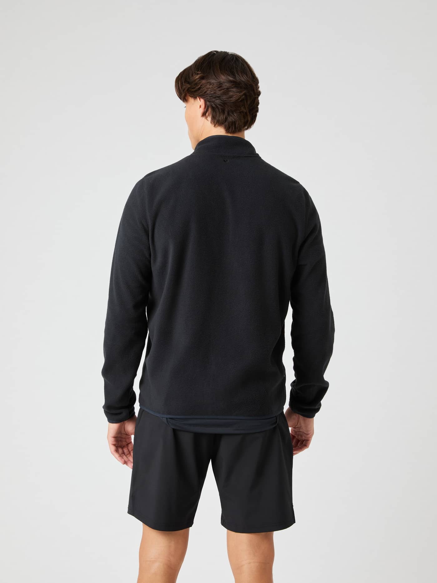 Back view of a man wearing the Borg Full Zip Fleece in Black Beauty (Black), made from functional recycled polyester. - Image 2
