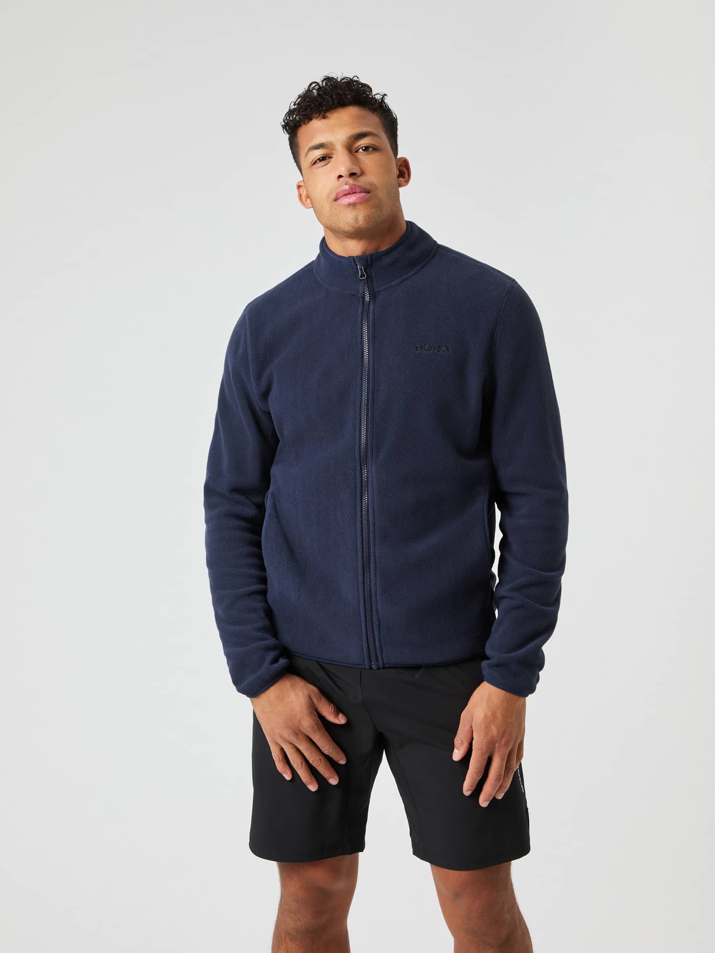 Front view of a man wearing the Borg Full Zip Fleece in Night sky (Navy), featuring a tonal logo and soft recycled fleece. - Image 2