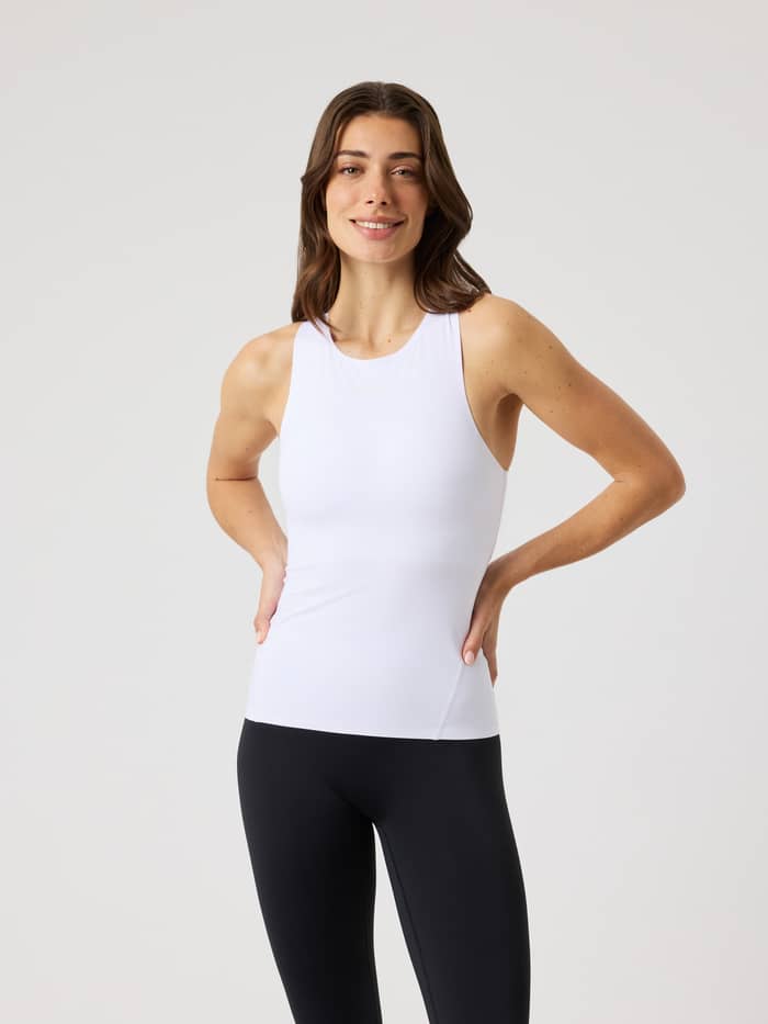 Front view of a woman wearing the stylish, slim-fit Borg 2 In 1 Tank Top in Brilliant White (White) for performance training.