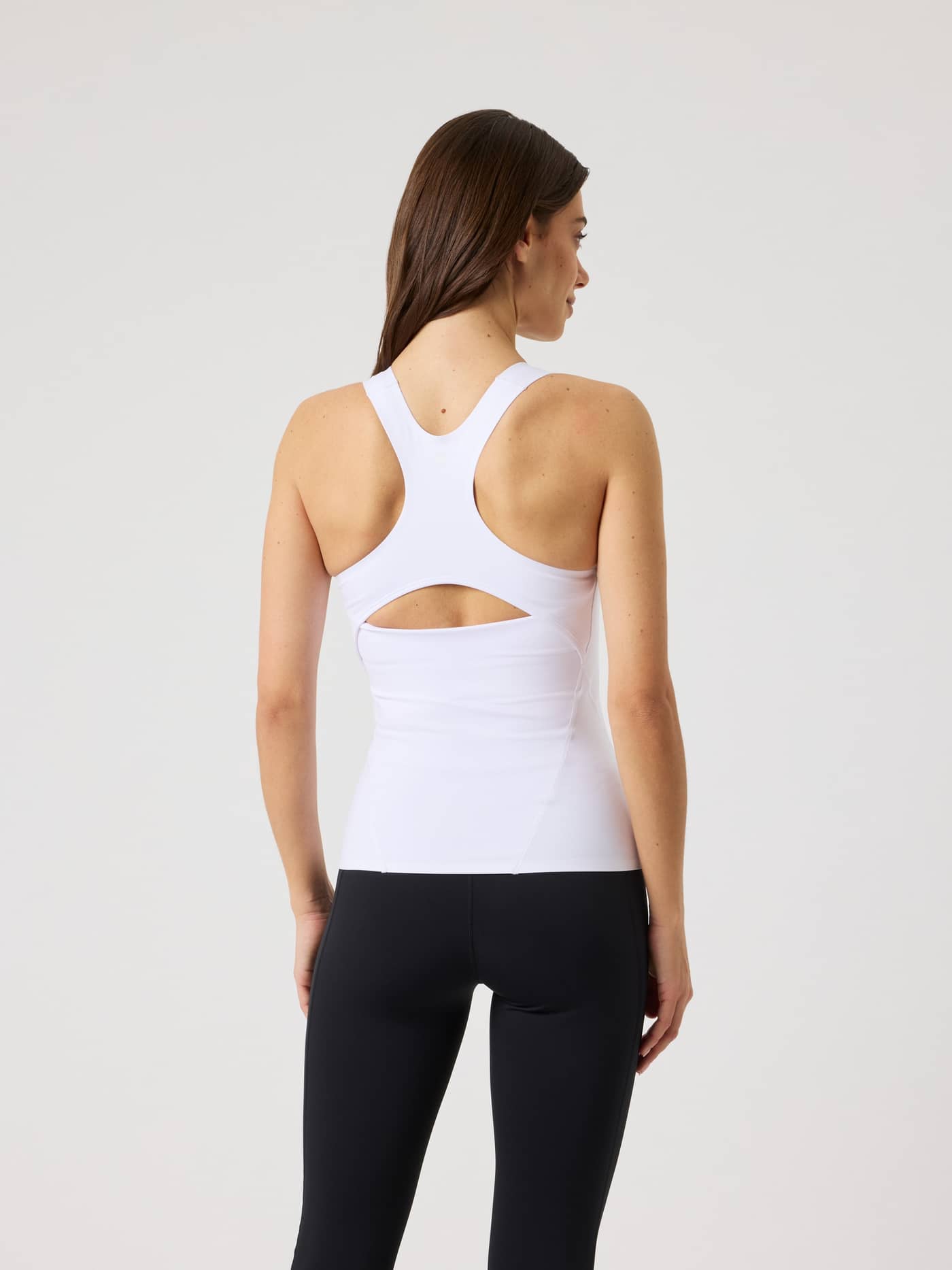 Back view of a model wearing the training Borg 2 In 1 Tank Top in Brilliant White (White) with a keyhole back. - Image 2