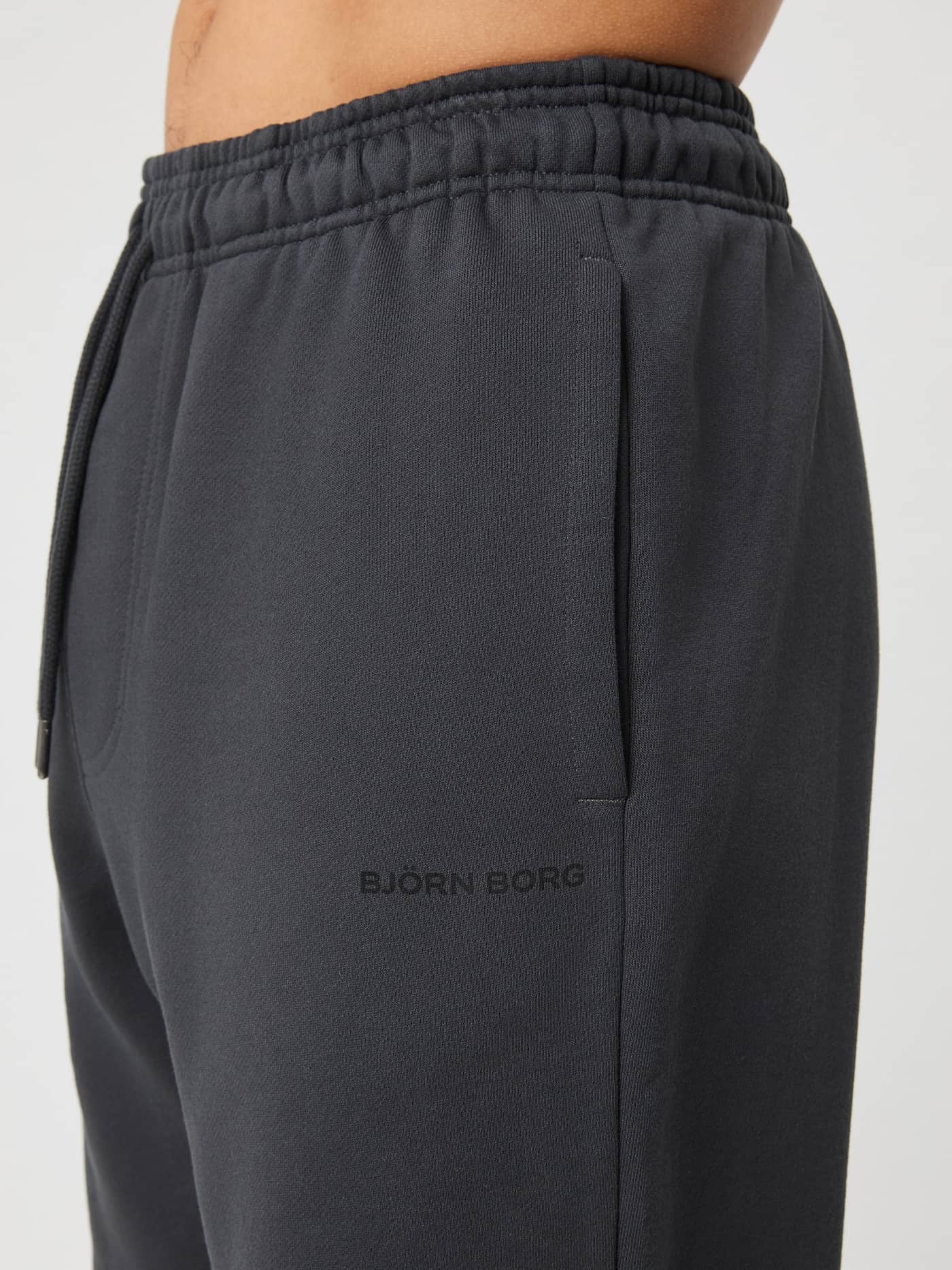 Borg Oversized Sweatpants i Asphalt (Grå) set fra siden med elastisk talje og et sort logo. - Image 4