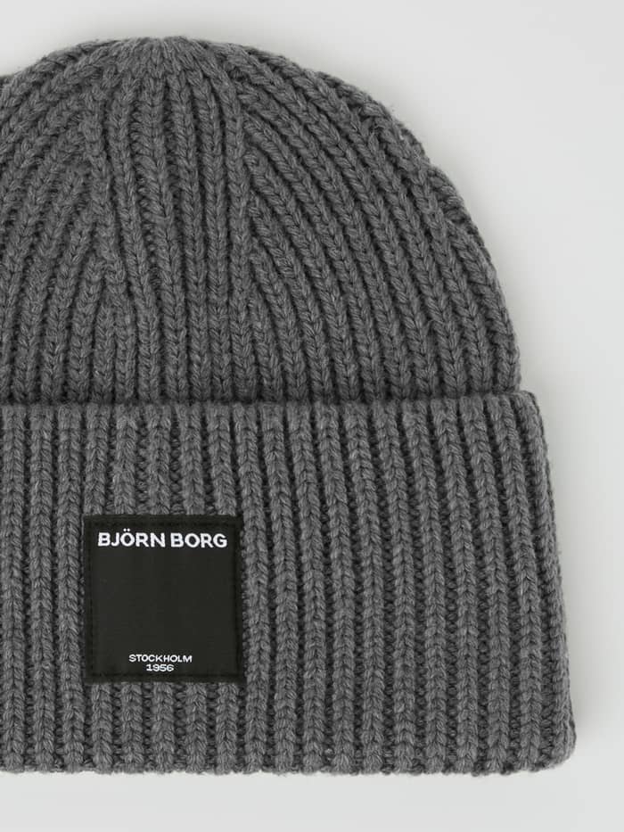 Close-up of the Centre Knit Beanie in Asphalt (Grey) with a ribbed texture and black logo label for training and leisure. - Image 3