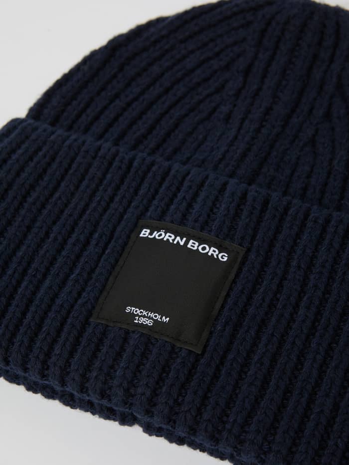 Close-up of the Night sky (Navy) Centre Knit Beanie, showcasing the soft ribbed knit material and front logo label. - Image 2