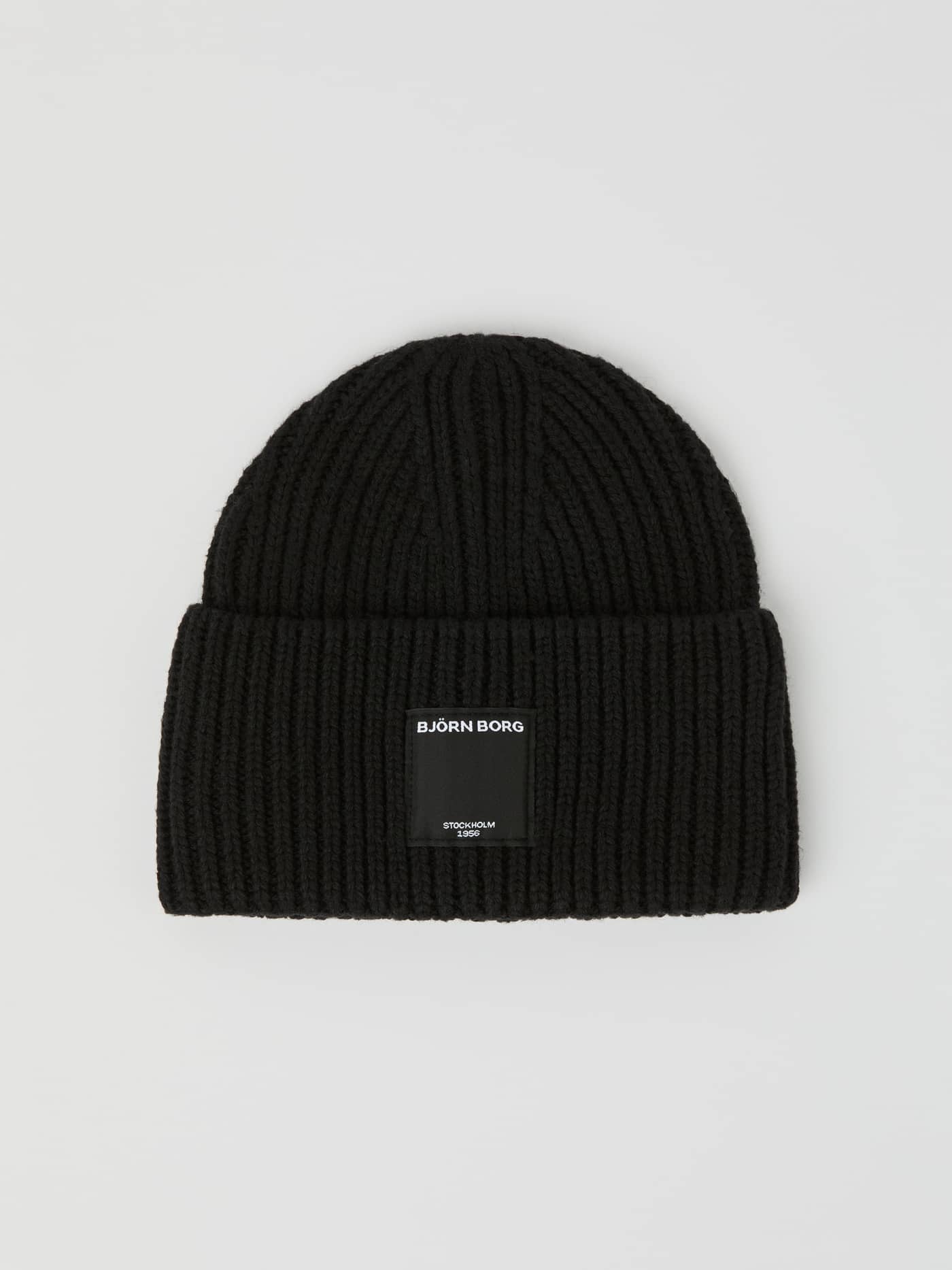 Ribbstickad Centre Knit Beanie i Black Beauty (Svart) sedd framifrån med uppvikt kant och en etikett framtill. - Image 1