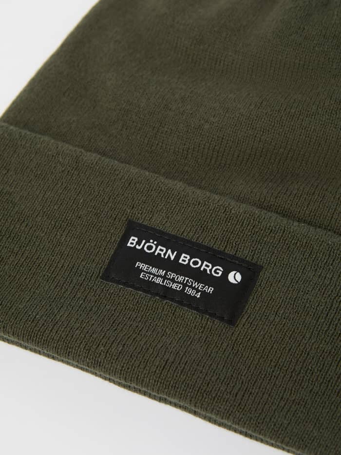 Detailed close-up of the Forest Night (Green) Centre Beanie in organic cotton, highlighting the brand label on the fold. - Image 2