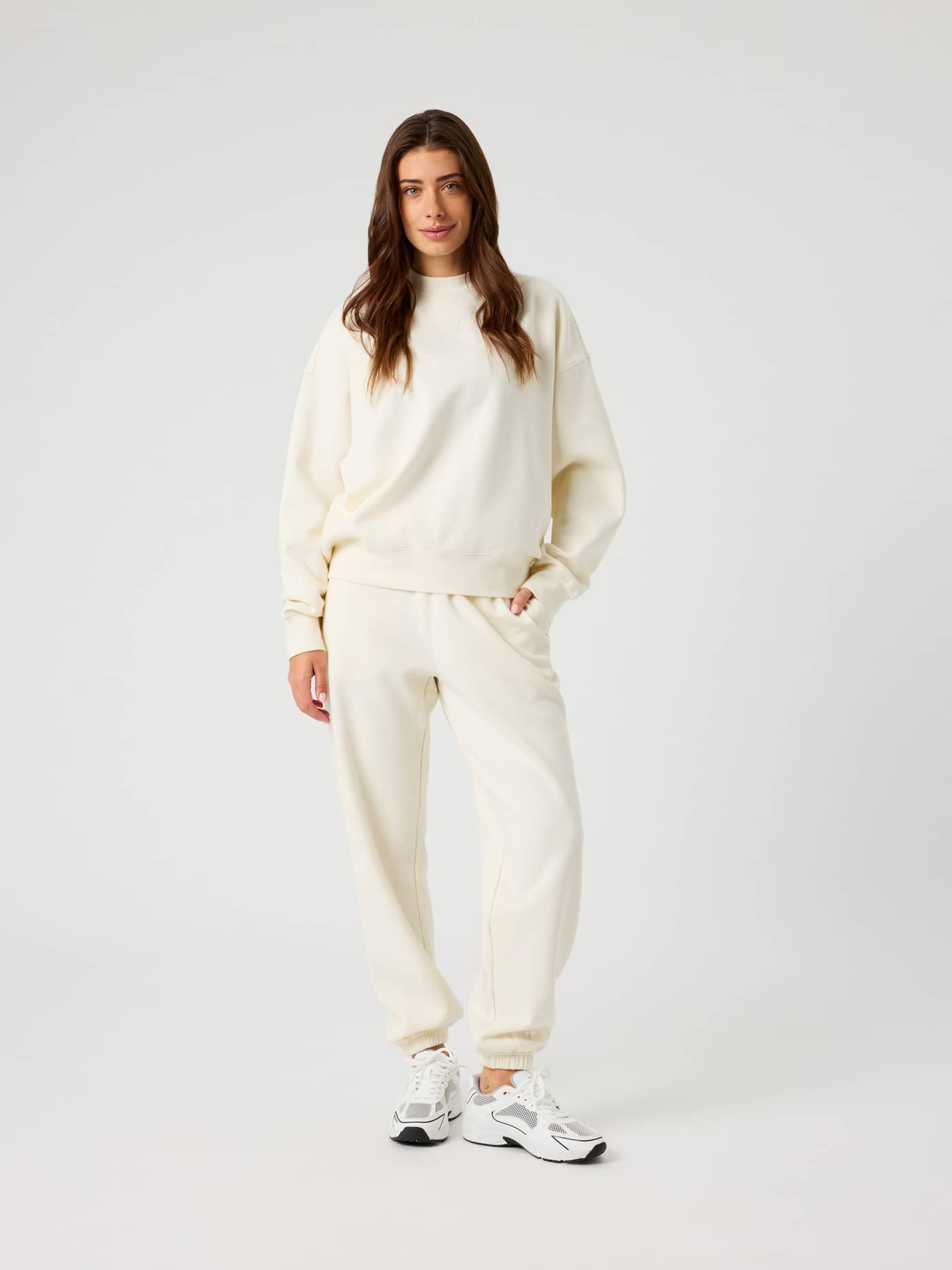 Full-body front view of a woman wearing the Studio Oversized Sweatpants in Tofu (White) for a relaxed leisure fit. - Image 3
