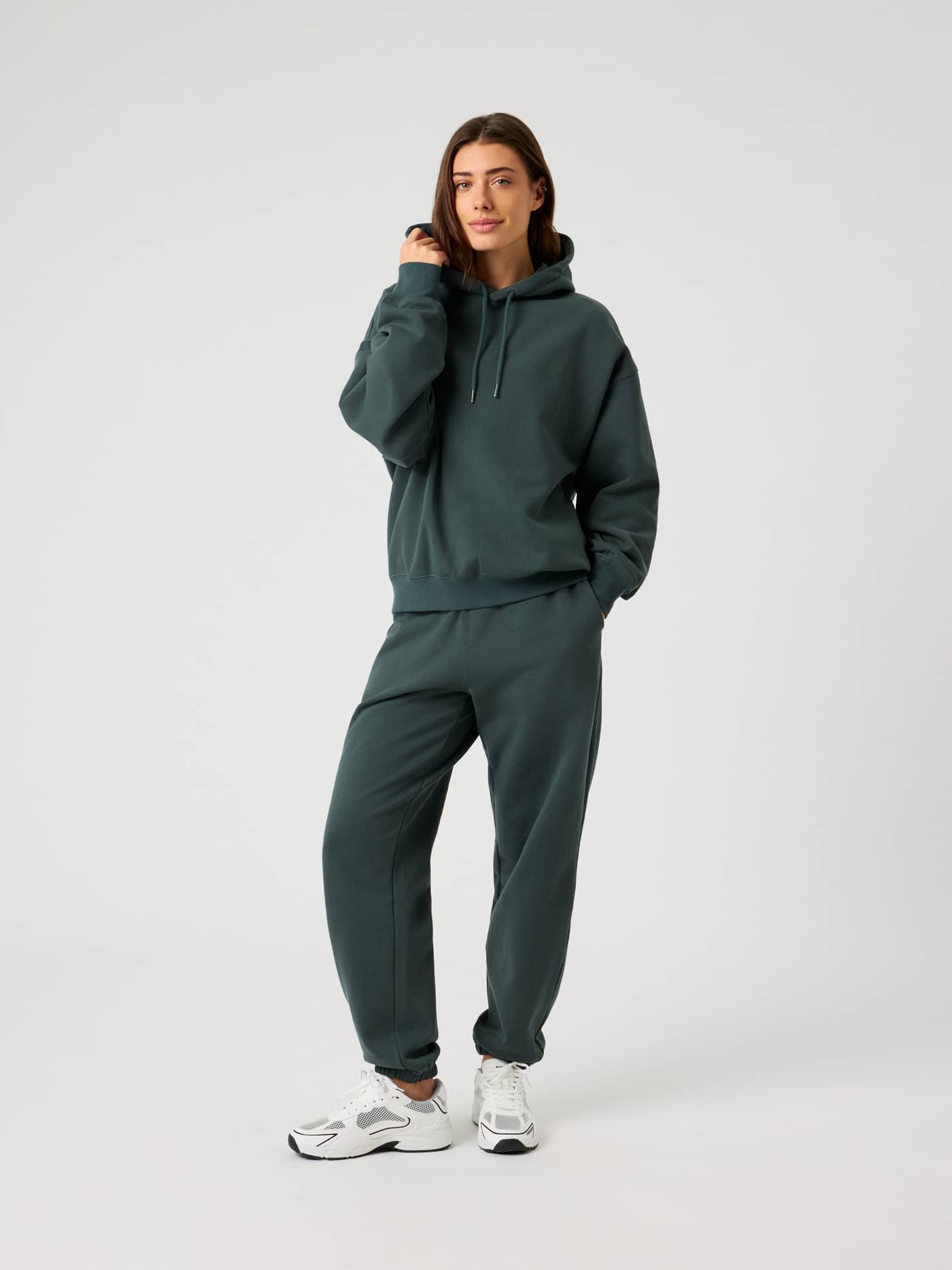 Ganzkörper-Vorderansicht einer Frau in Studio Oversized Sweatpants in Urban Chic (Grün) mit stylisher, entspannter Passform. - Image 3