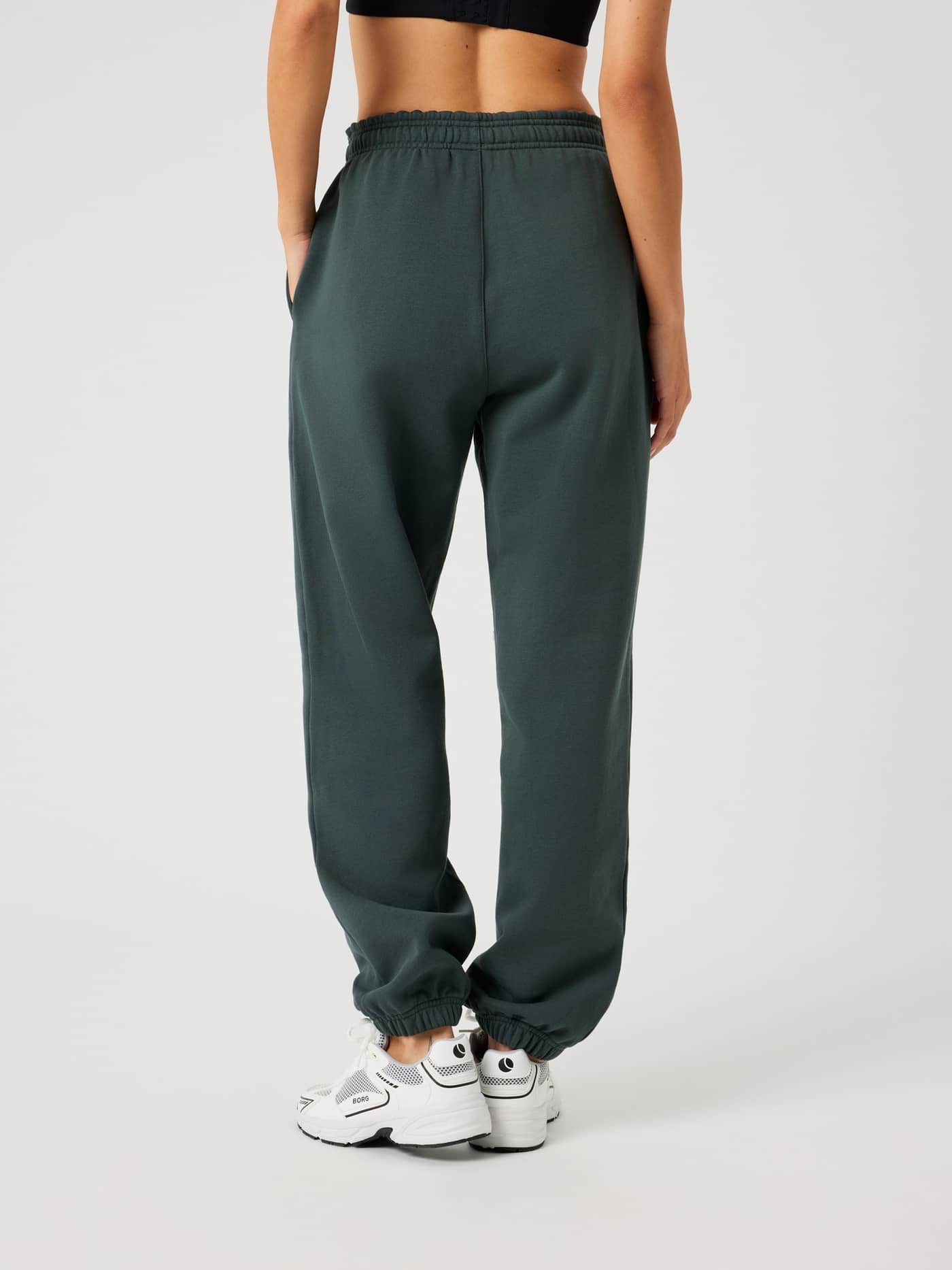 Rückansicht eines Models in Björn Borg Studio Oversized Sweatpants in Urban Chic (Grün) mit hoher, lockerer Passform. - Image 2