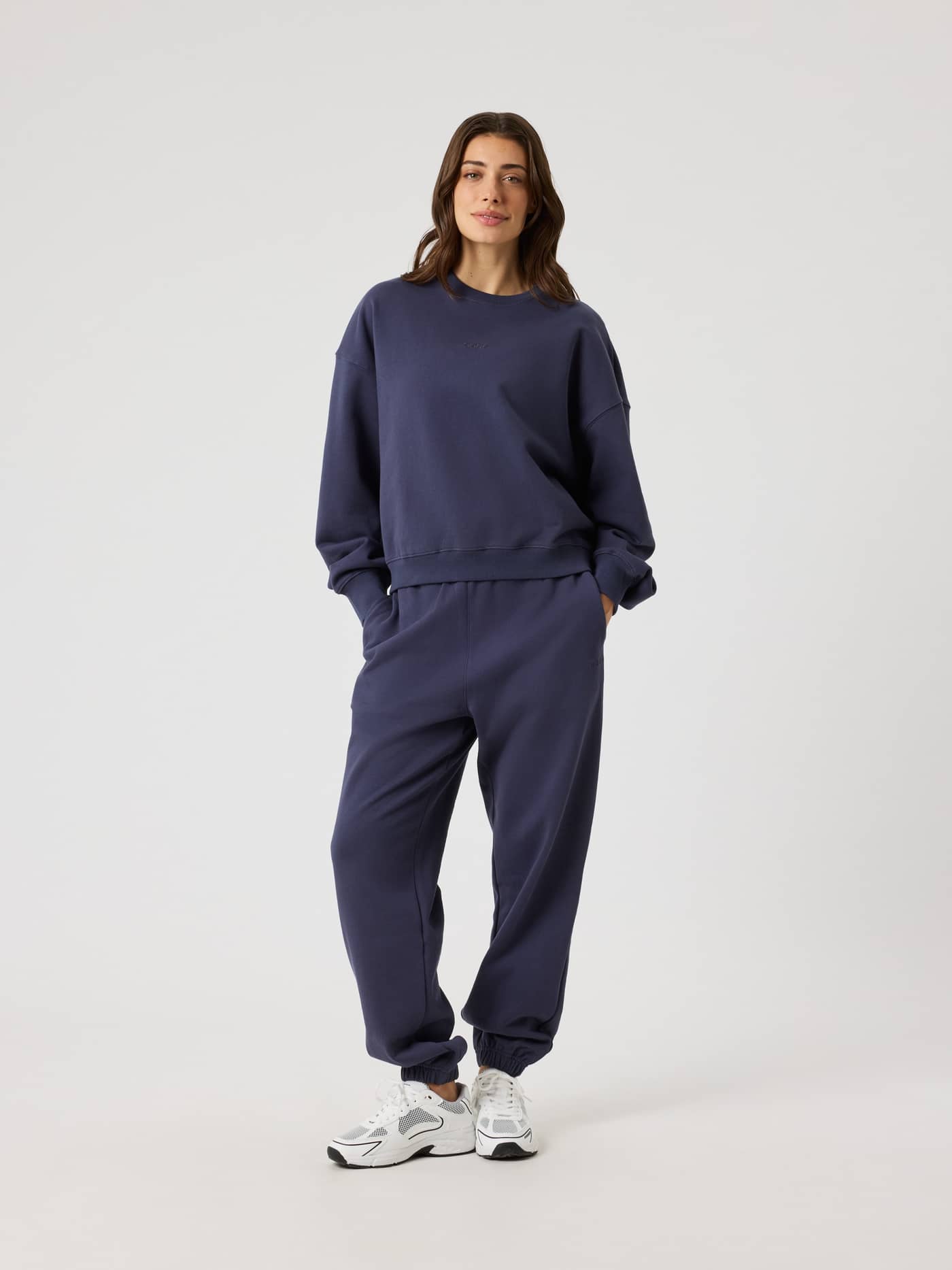 Full-body front view of a woman wearing the high-waisted Studio Oversized Sweatpants in Odyssey Gray (Navy). - Image 3