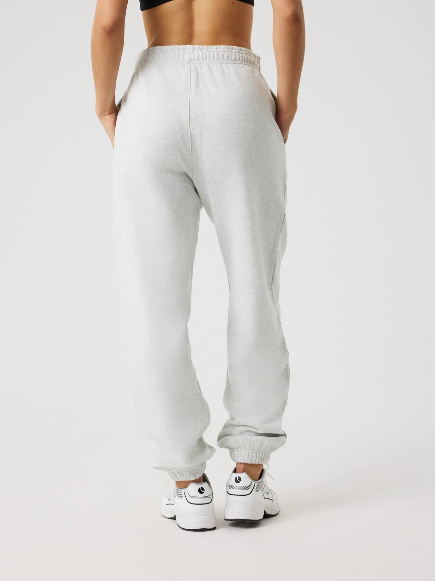 Back view of a model wearing the Studio Oversized Sweatpants in Ultra Light Grey Melange (Grey) with a relaxed fit. - Image 2
