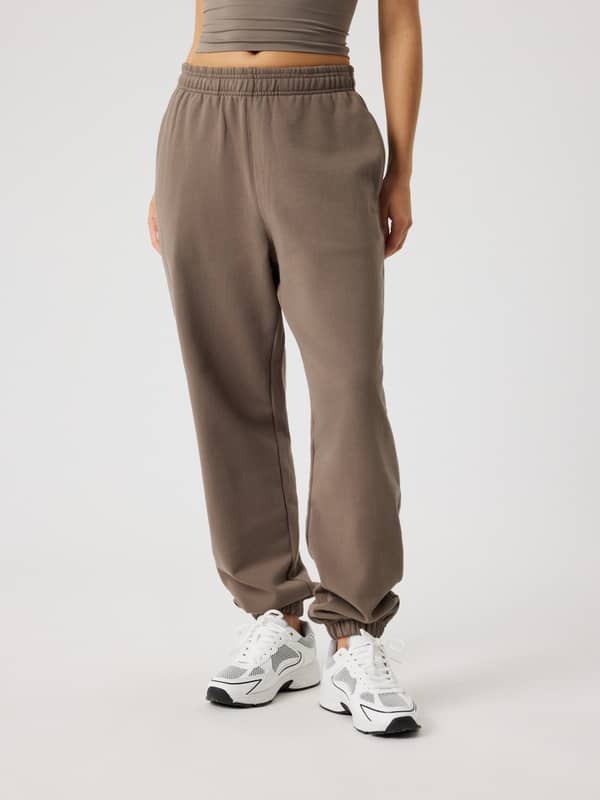 Front view of a model wearing high-waisted Studio Oversized Sweatpants in Falcon (Brown) made from a soft cotton blend.