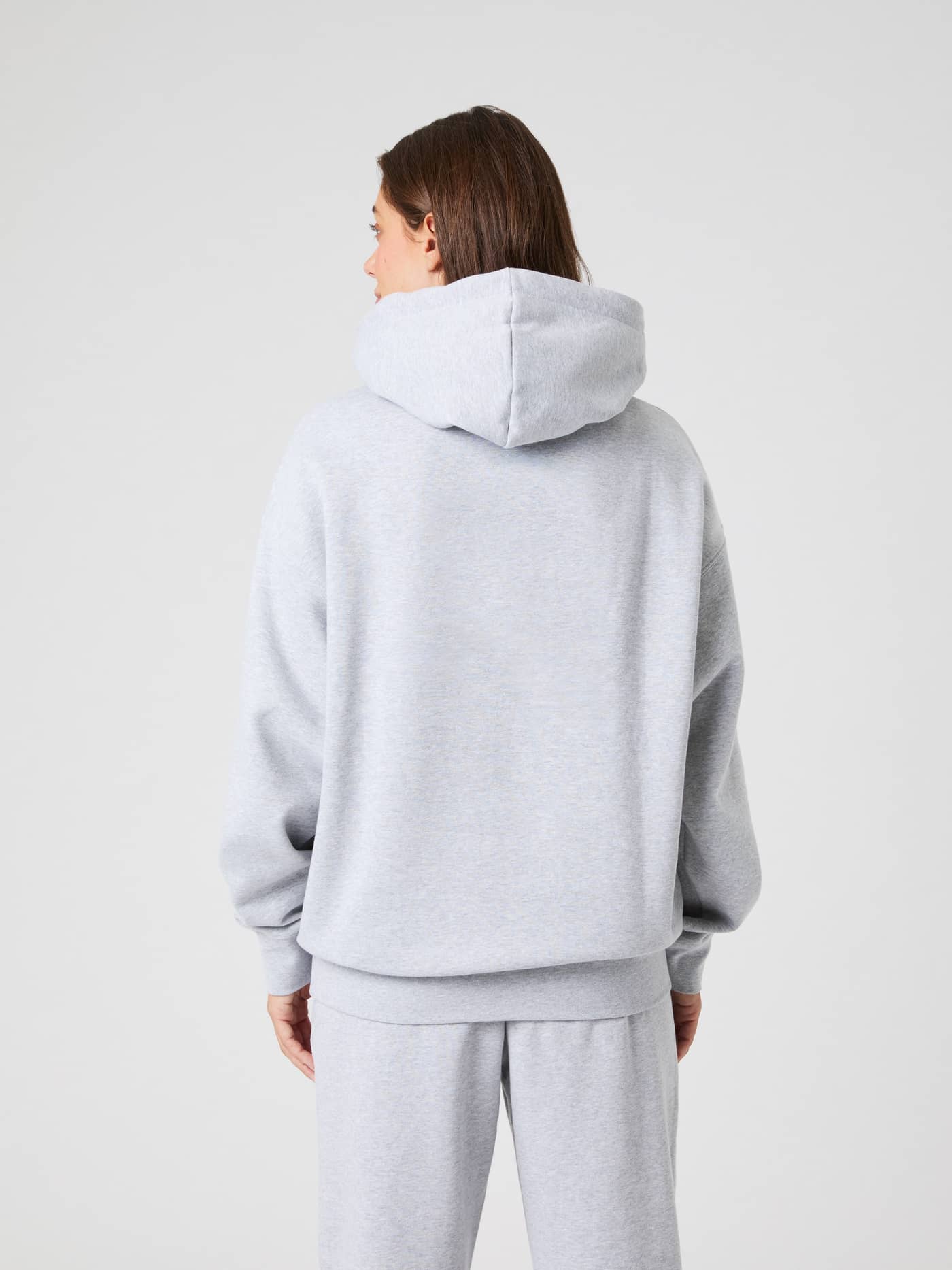 Studio Oversized Hoodie in light grey melange, shown from the back on a model. - Image 3