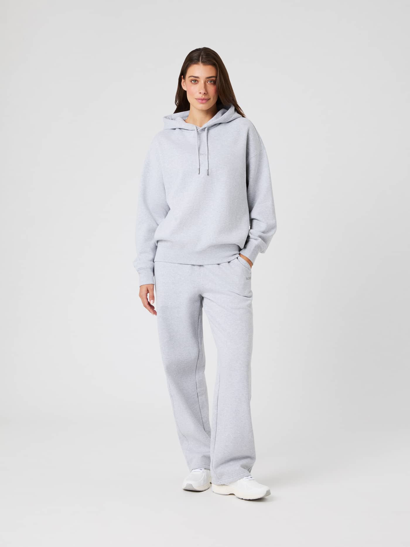 Full-body front view of a woman wearing the Studio Oversized Hoodie in Light Grey Melange (Grey) with a relaxed fit. - Image 4